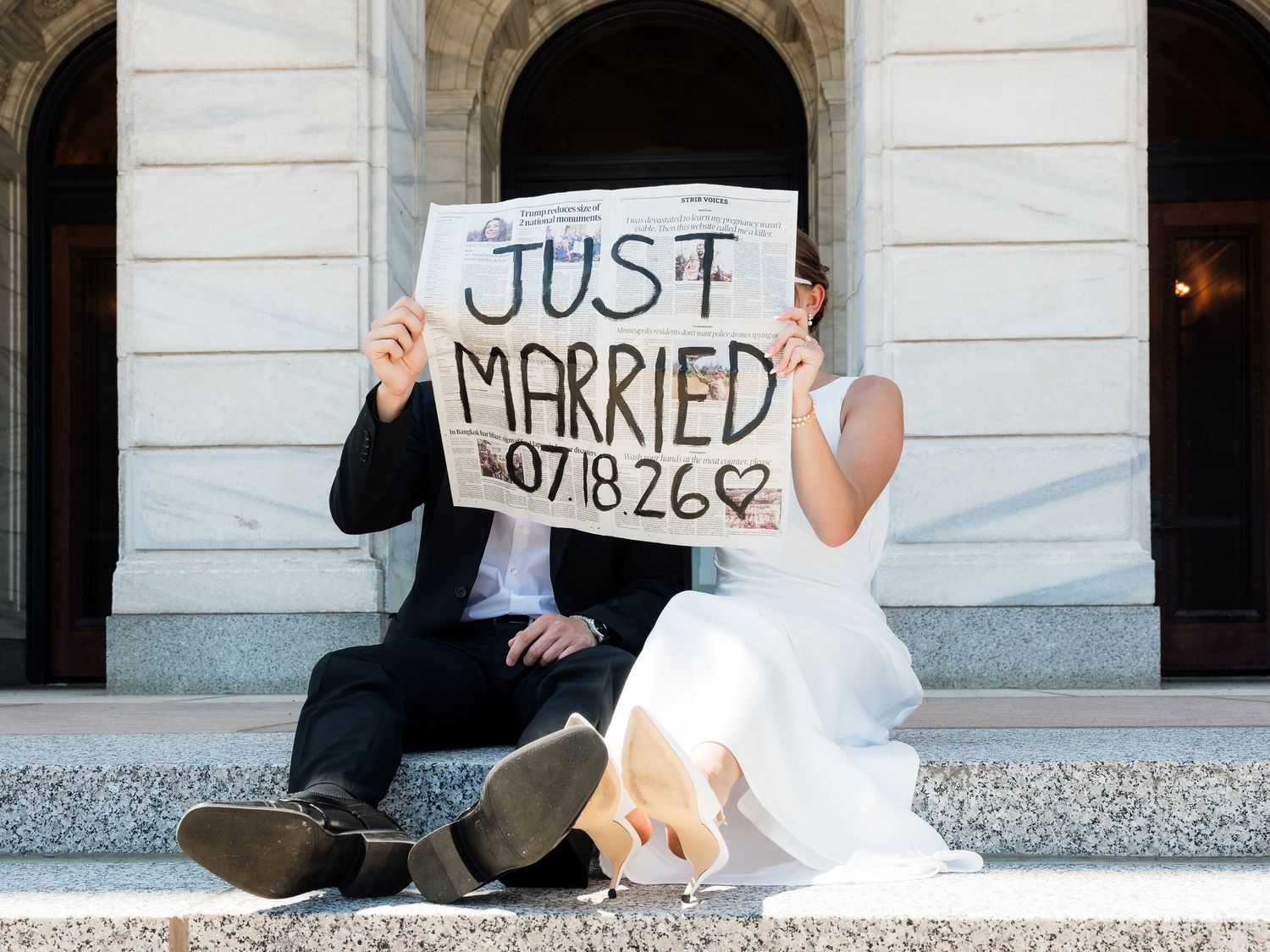 Newlyweds holding Just Married sign on steps dated 07.18.26.