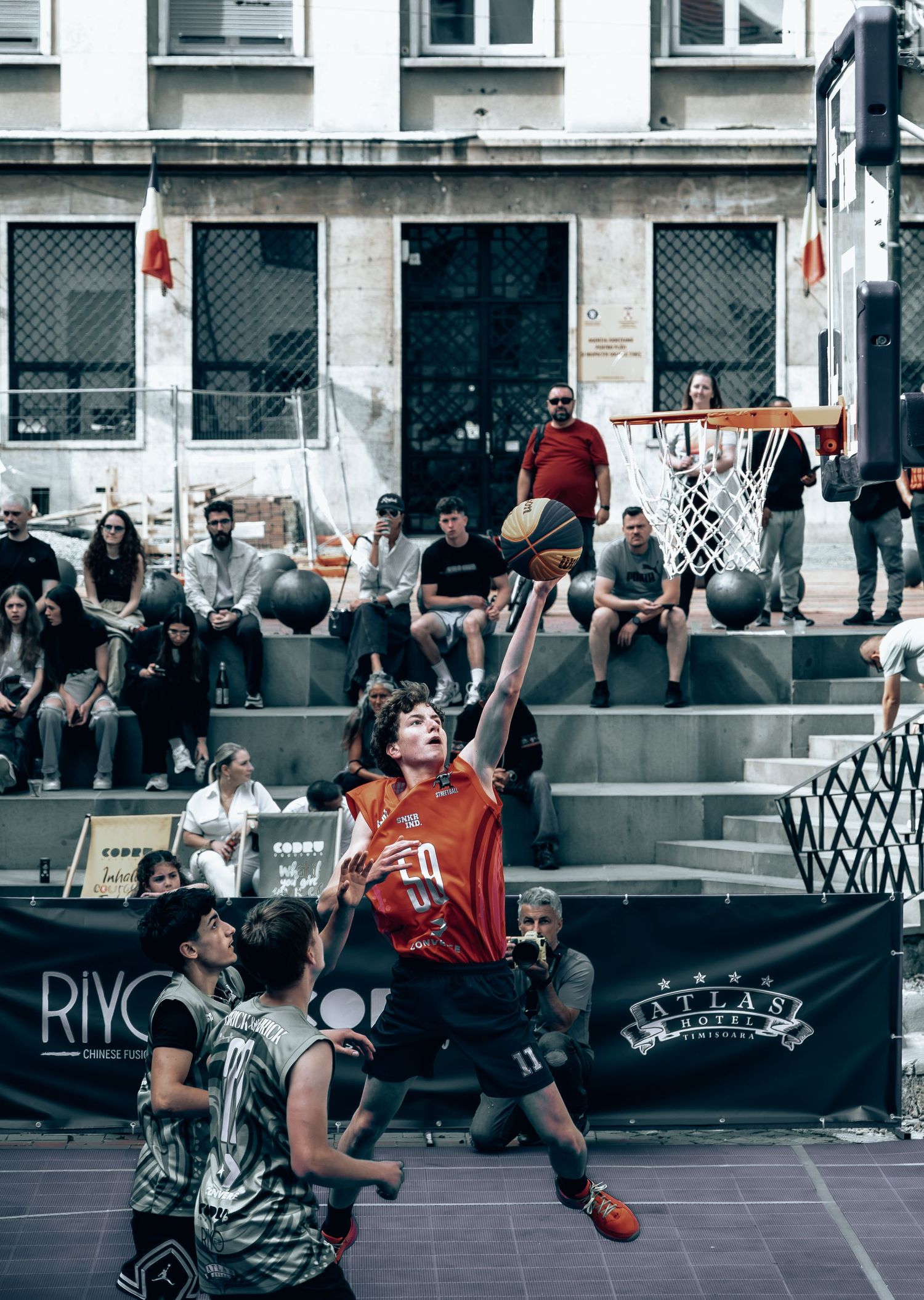 Street basketball player leaping toward the hoop during an outdoor 3x3 tournament.