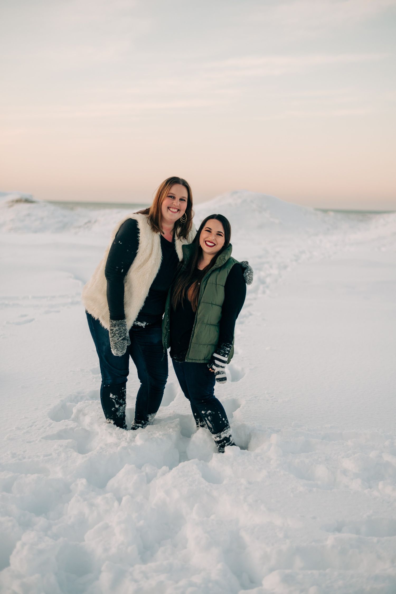photo of two women on a snowy beach at sunset