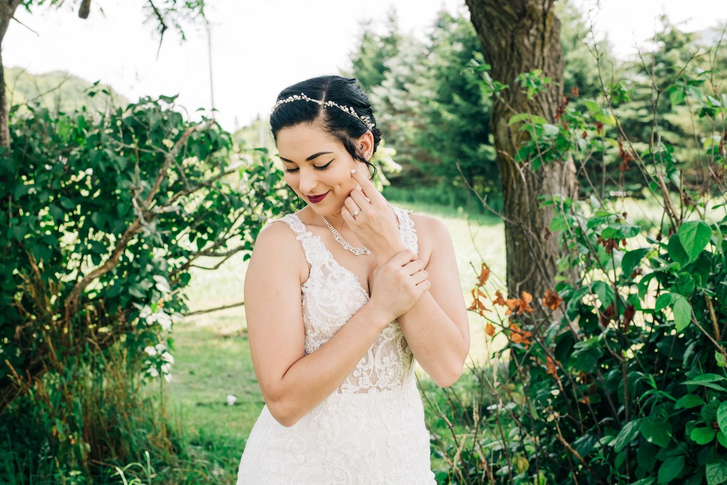 bride looking at ground with her hand resting on her face