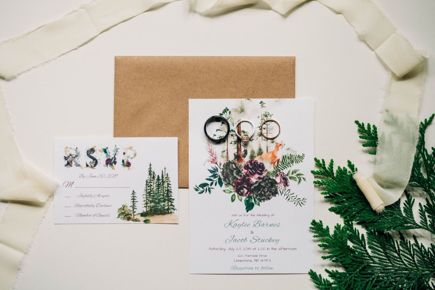 flat lay of wedding invitation and rings