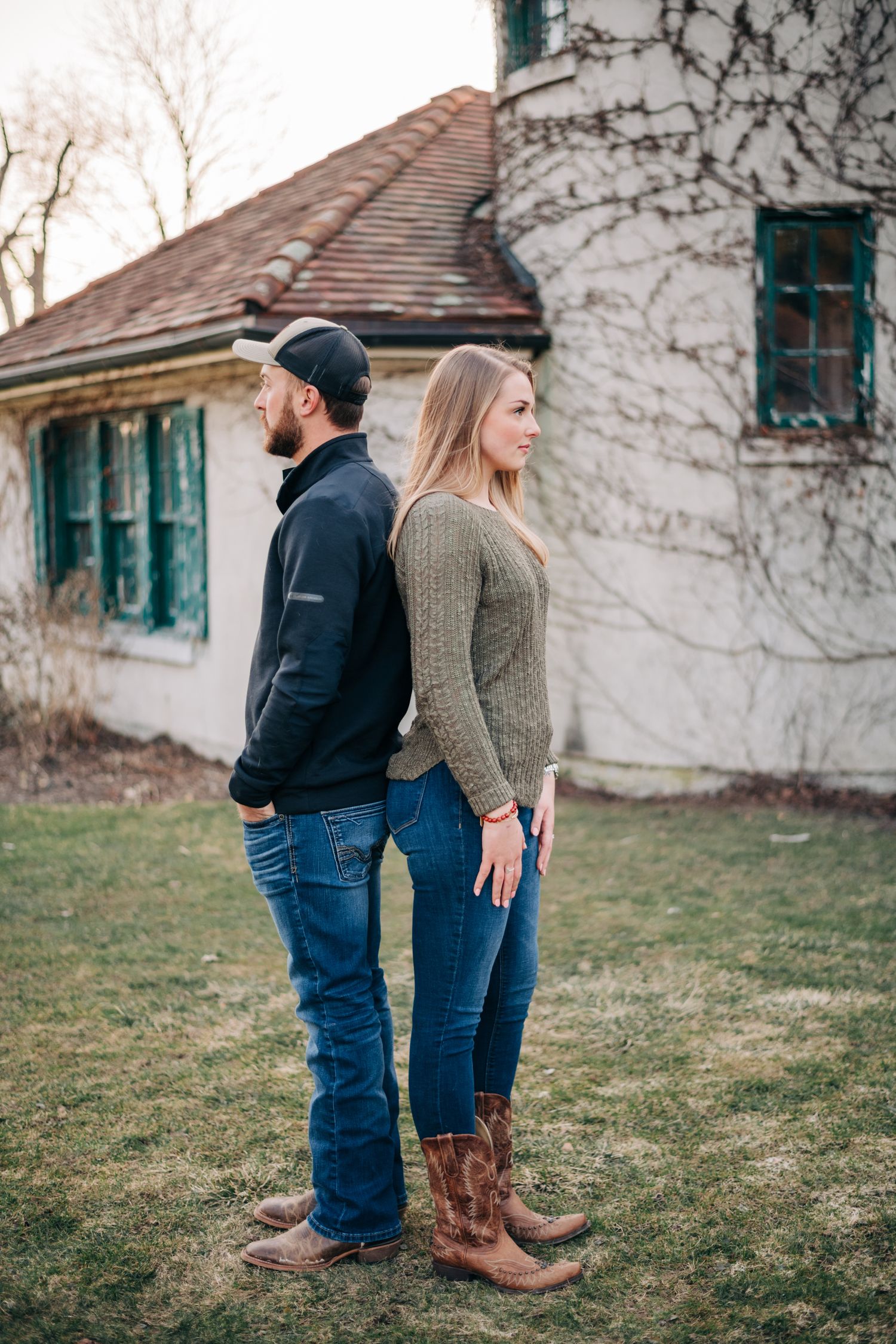 man and woman standing back to back looking away from each other