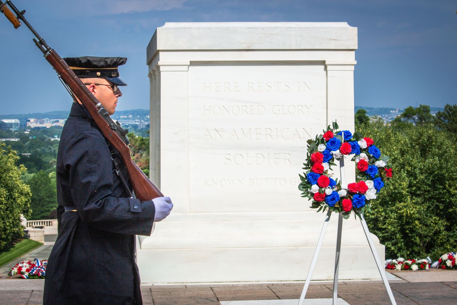 Military guard marching at the Tomb of the Unknown Soldier with a patriotic wreath at Arlington.