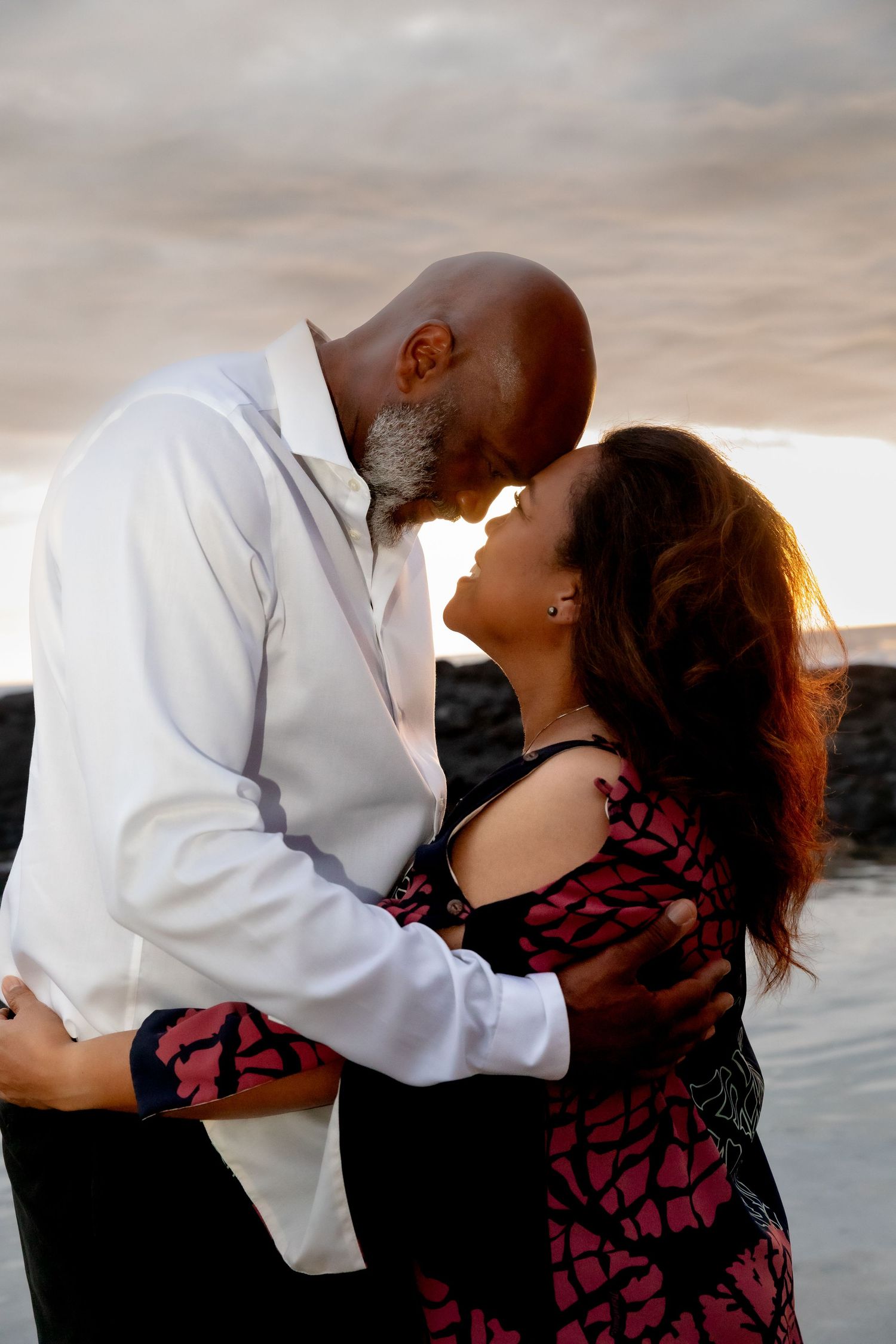 Romantic couple sharing an intimate moment on beach at sunset.
