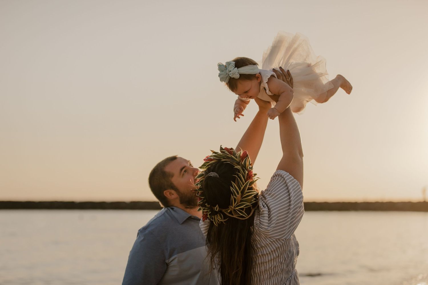 A joyful family moment captured at sunset by the water.