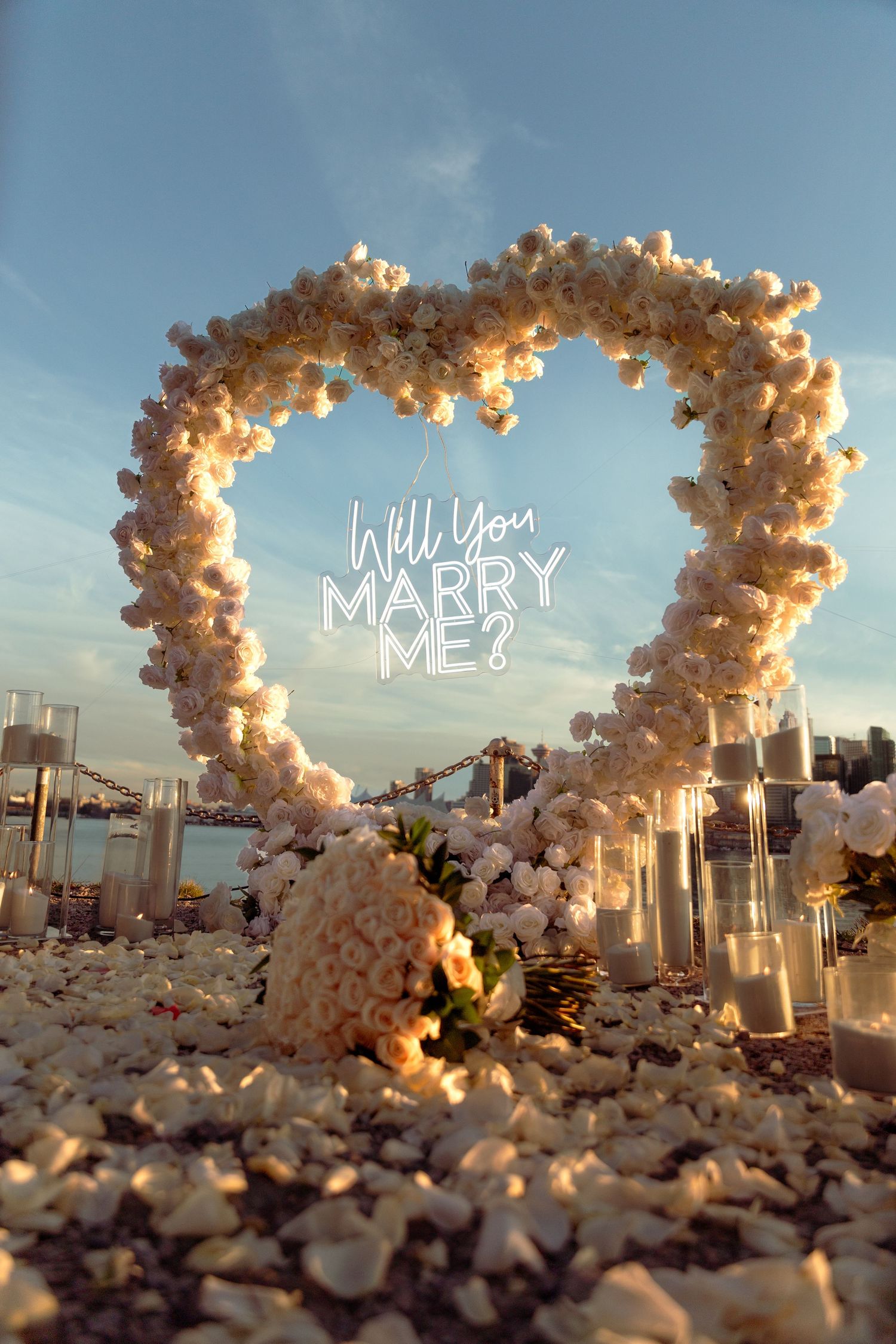 Heart-shaped floral proposal setup with 'Will you marry me' sign