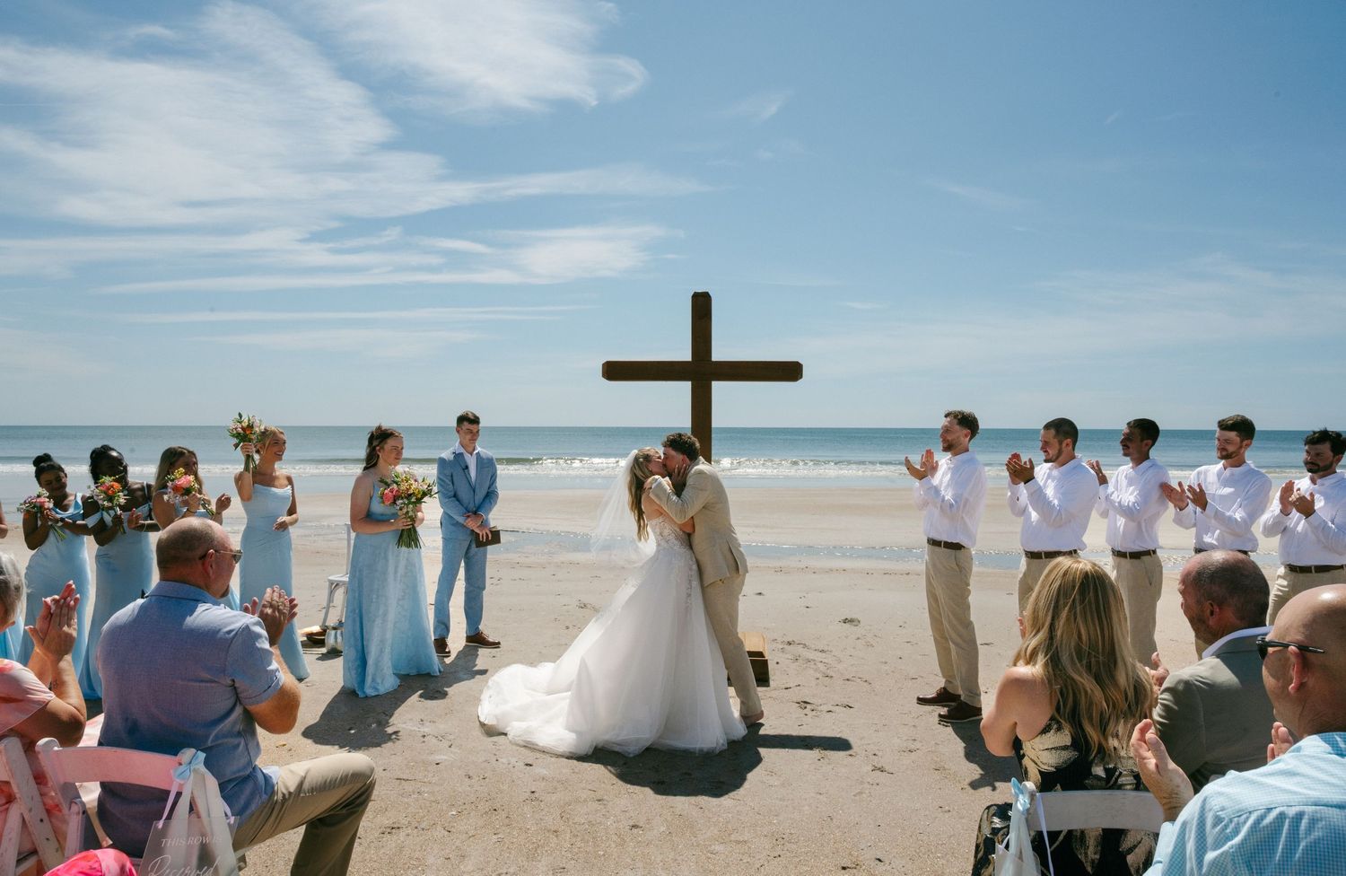 Couple has first kiss on the beach as husband and wife on their wedding day on Amelia Island, Florida