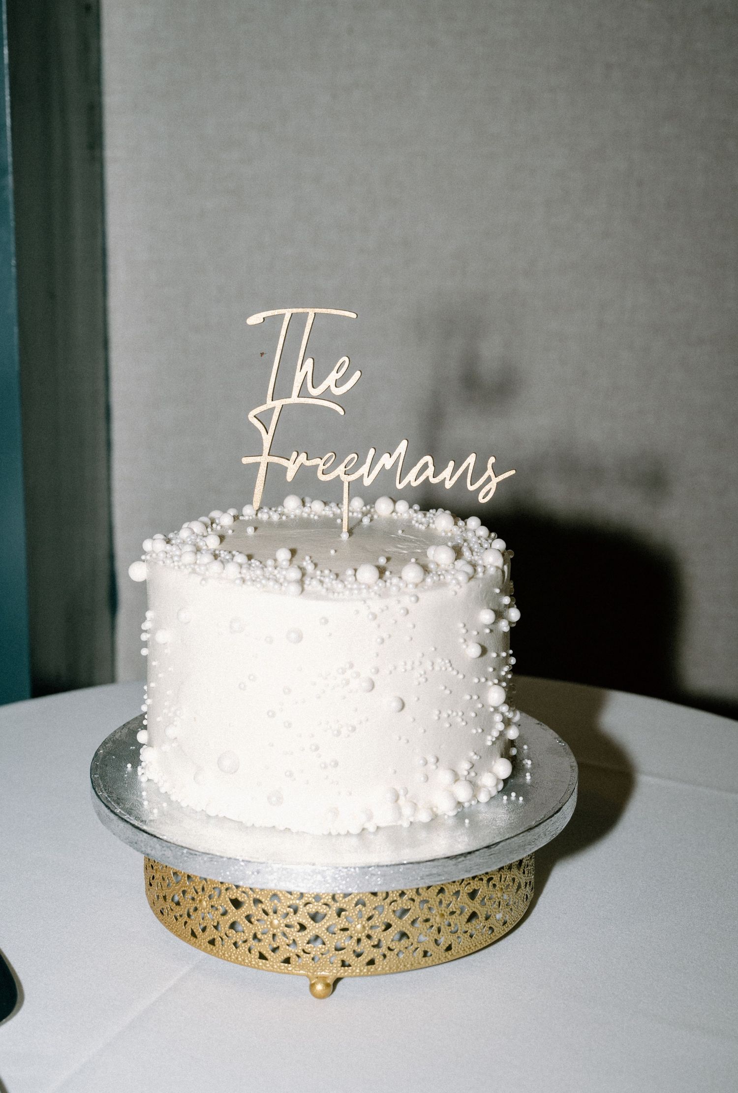 Wedding cake with pearls and a custom wooden sign