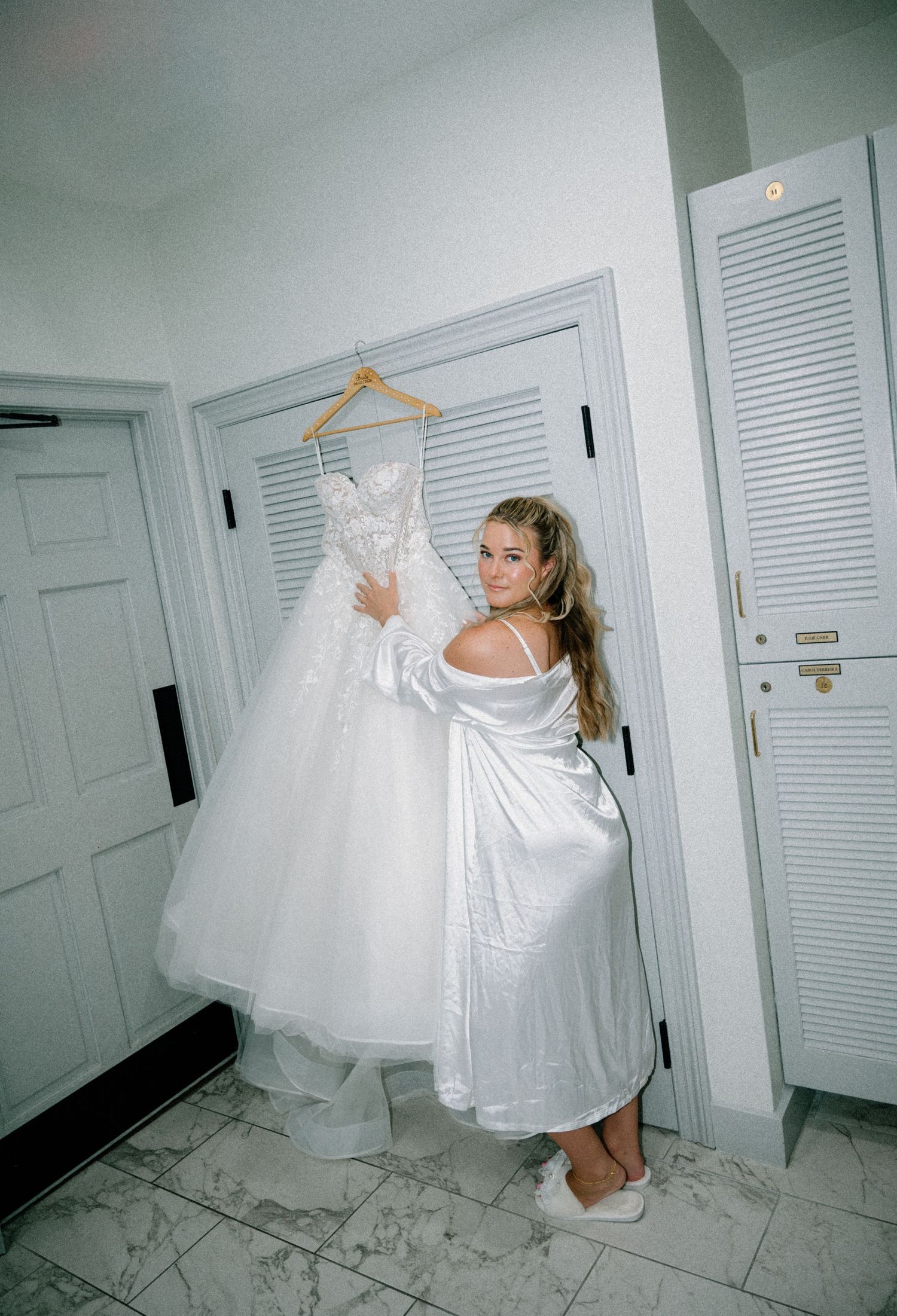 Bride looking at her wedding dress while getting ready on her wedding day at The Ritz-Carlton on Amelia Island, Florida