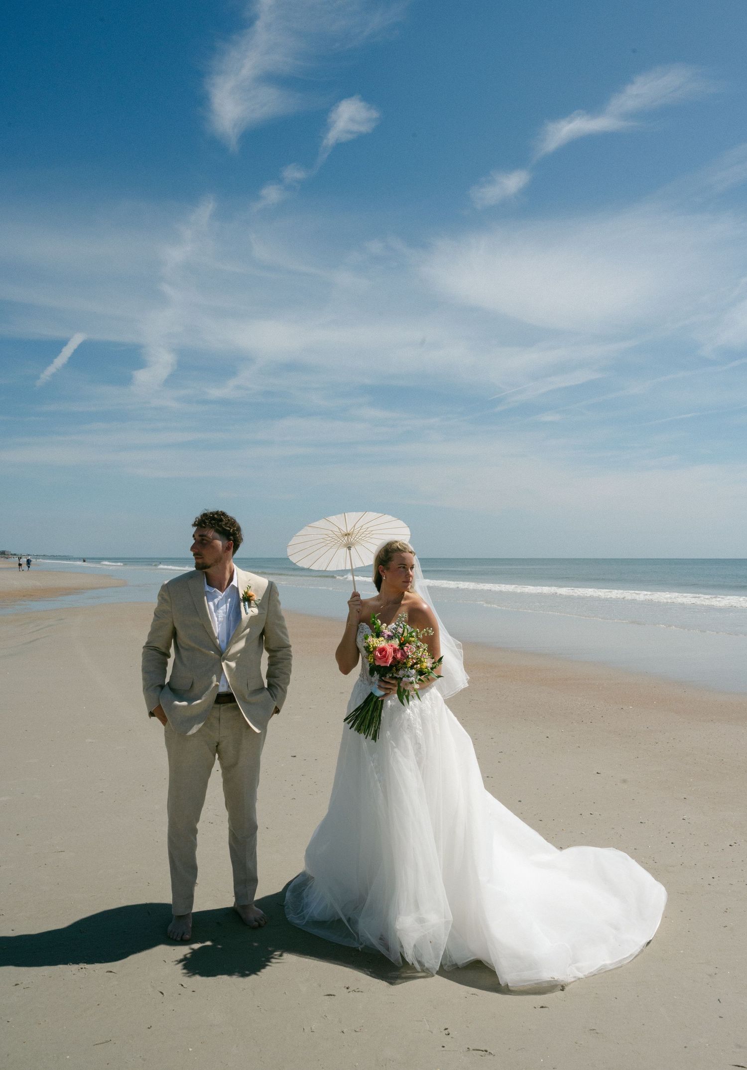 Bride and groom posing on the beach together after their wedding ceremony on Amelia Island, Florida