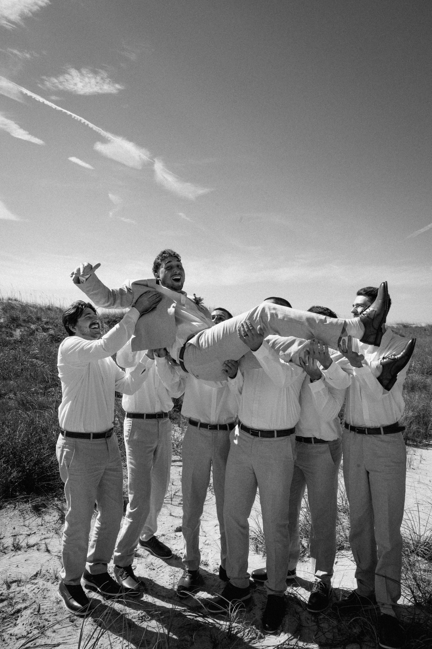 Groomsmen throwing the groom up in the air on his wedding day on Amelia Island