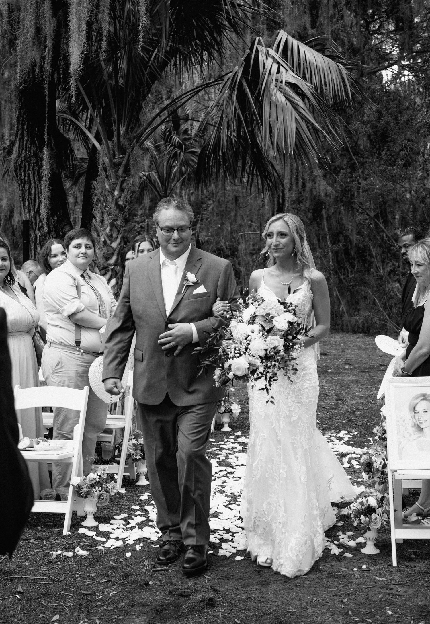 Father walks bride down the aisle in black and white outdoor wedding ceremony photo at Walker's Landing on Amelia Island, Florida.