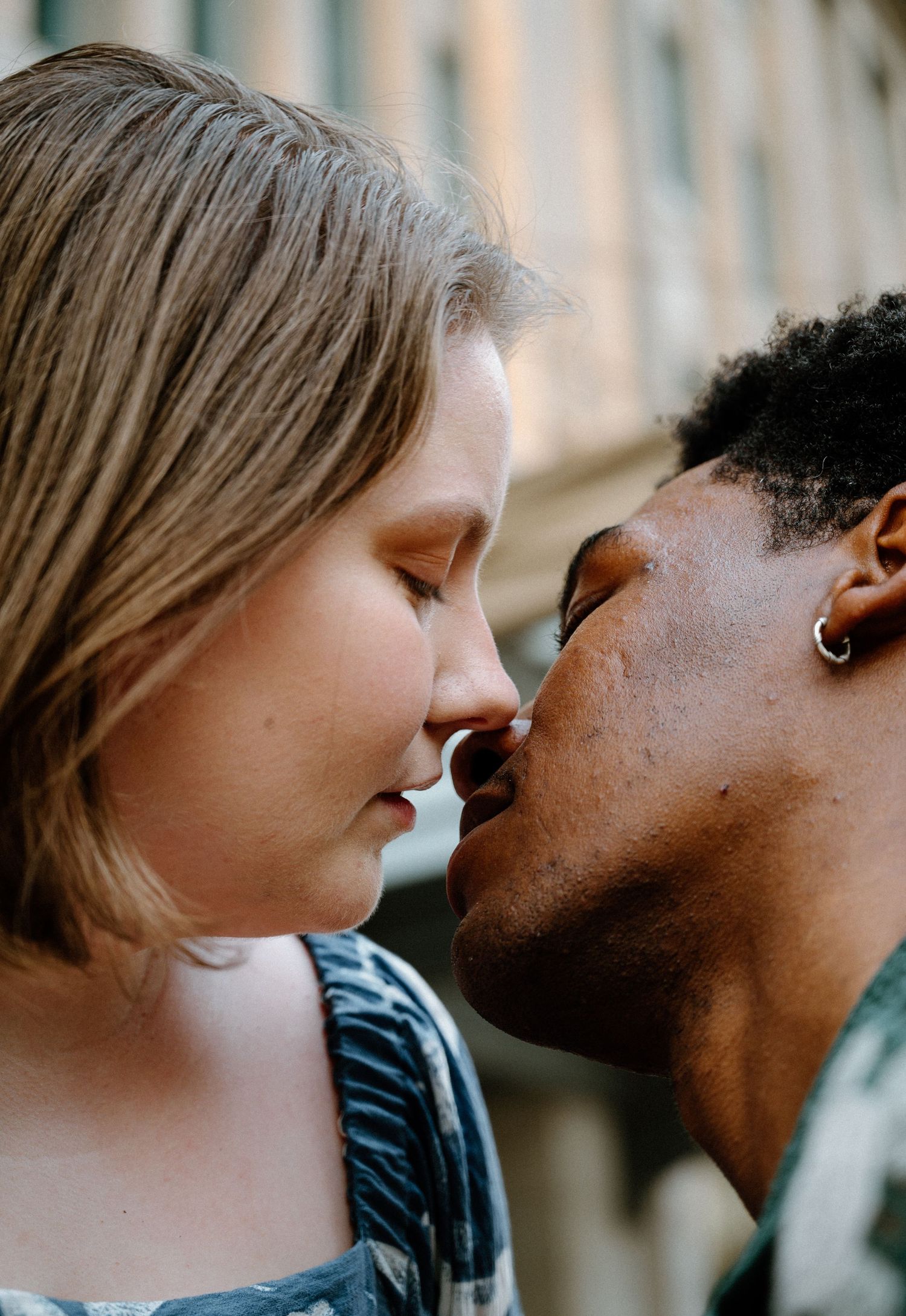 Close-up of an interracial couple sharing a tender intimate moment, nearly kissing outdoors in Jacksonville, Florida.
