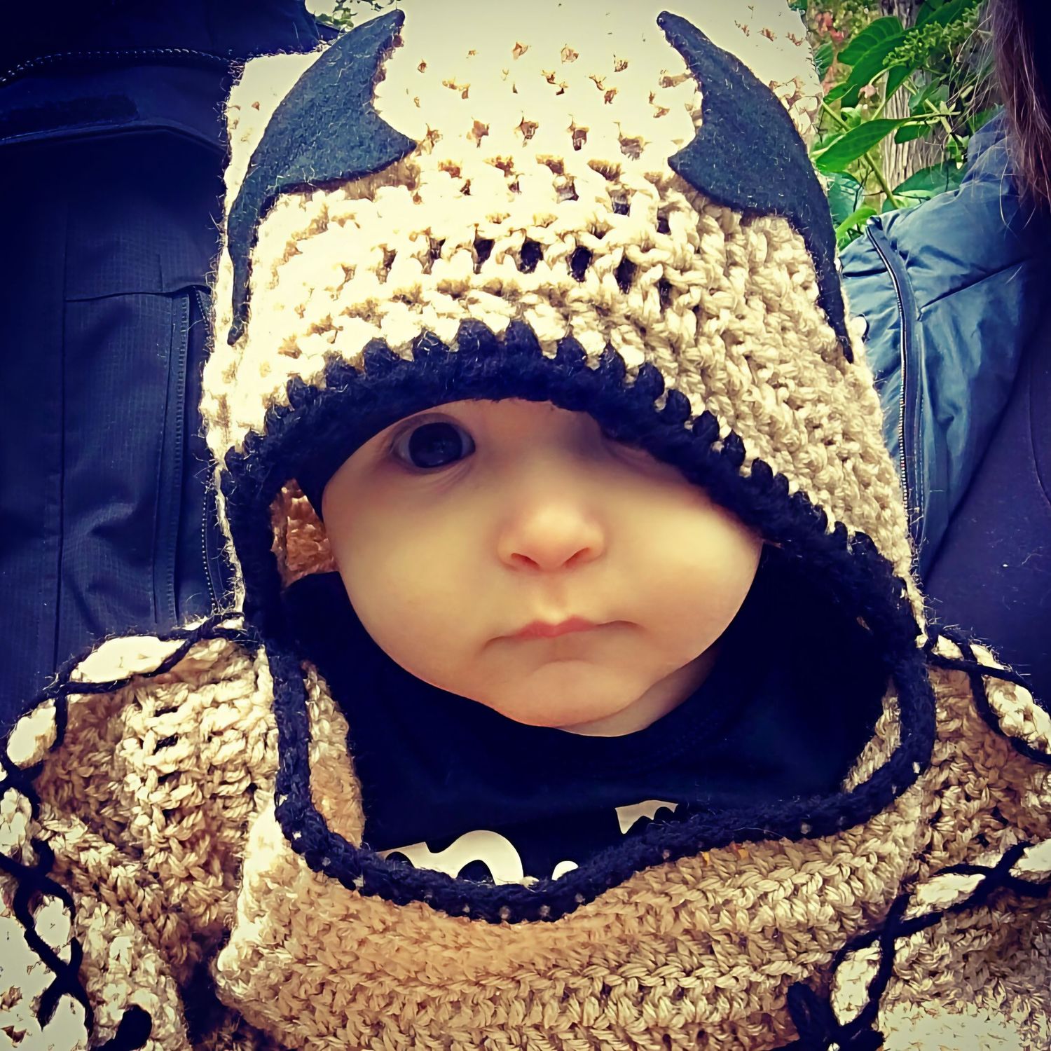 Adorable baby wearing handmade crochet Oogey Boogey costume outdoors.