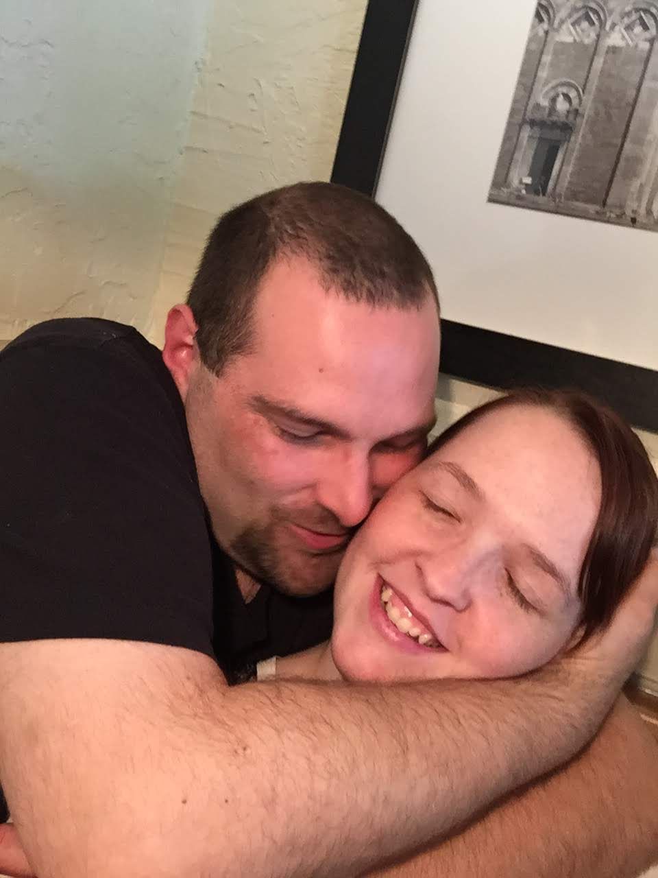 Couple sharing a tender embrace and smiling together indoors.