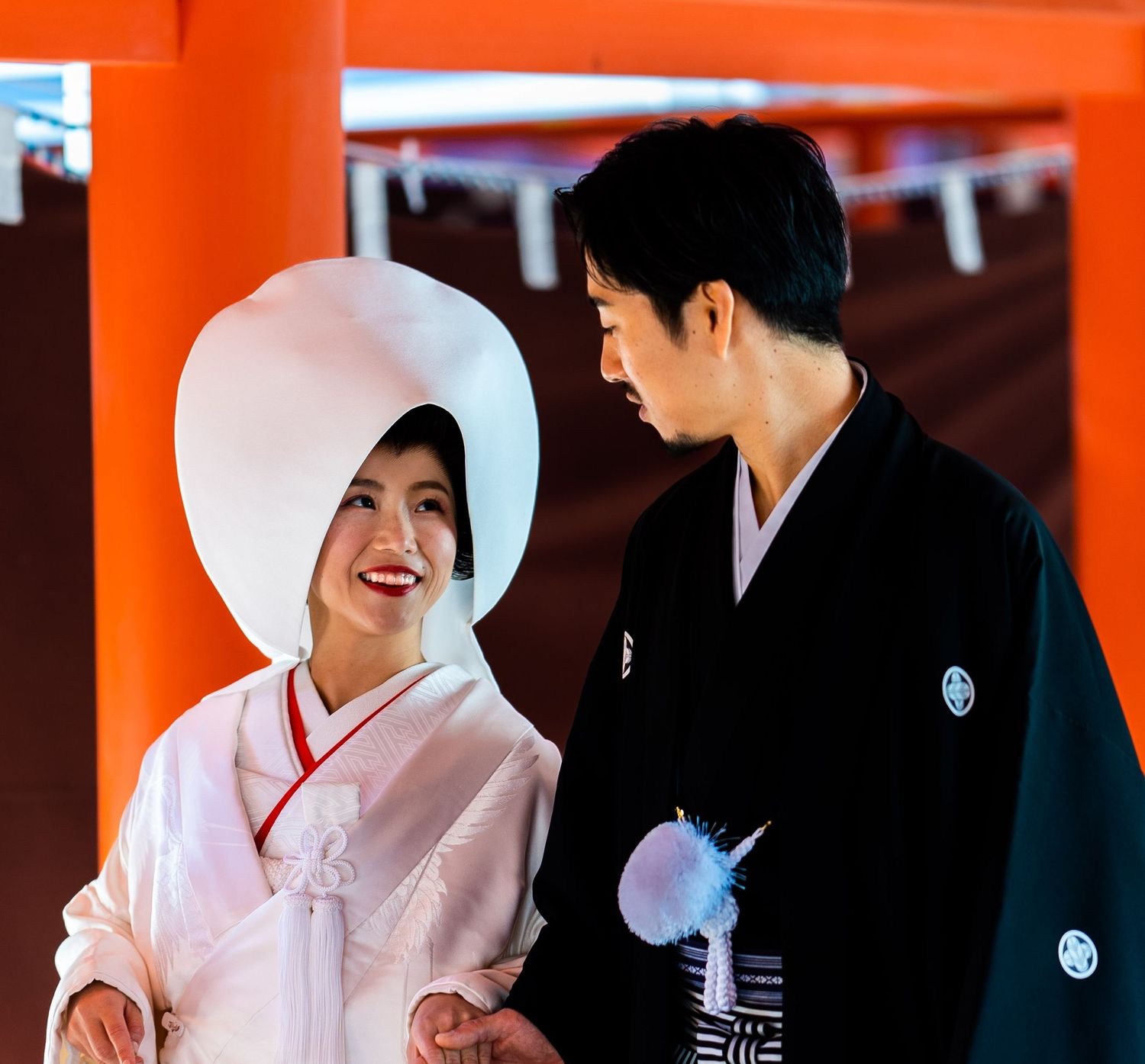 Japanese bride in white shiromuku kimono and wataboshi hat with groom in black montsuki.