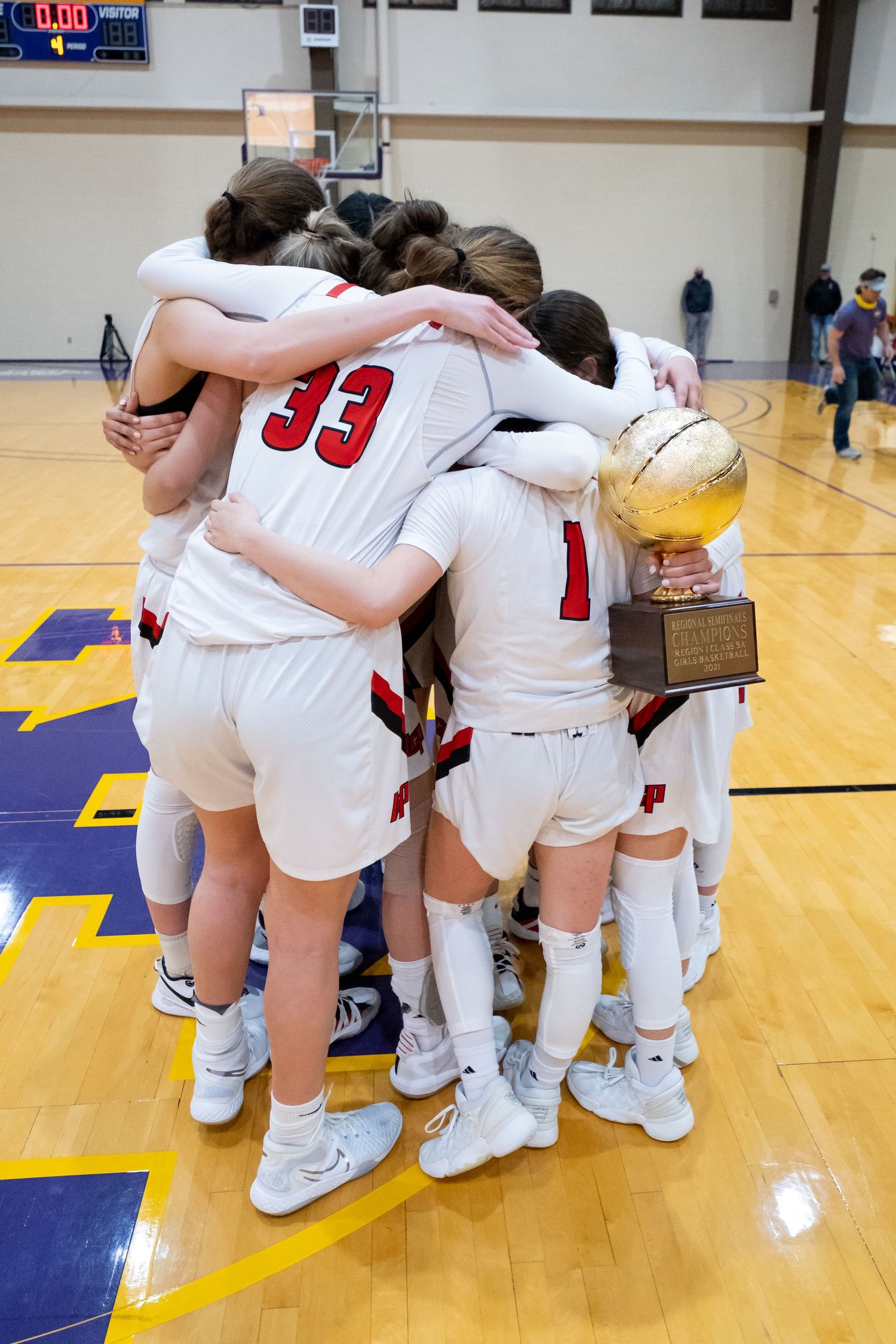 The Lady Pirates surround and embrace an injured Avrie Douglas after receiving the regional semi-final trophy.