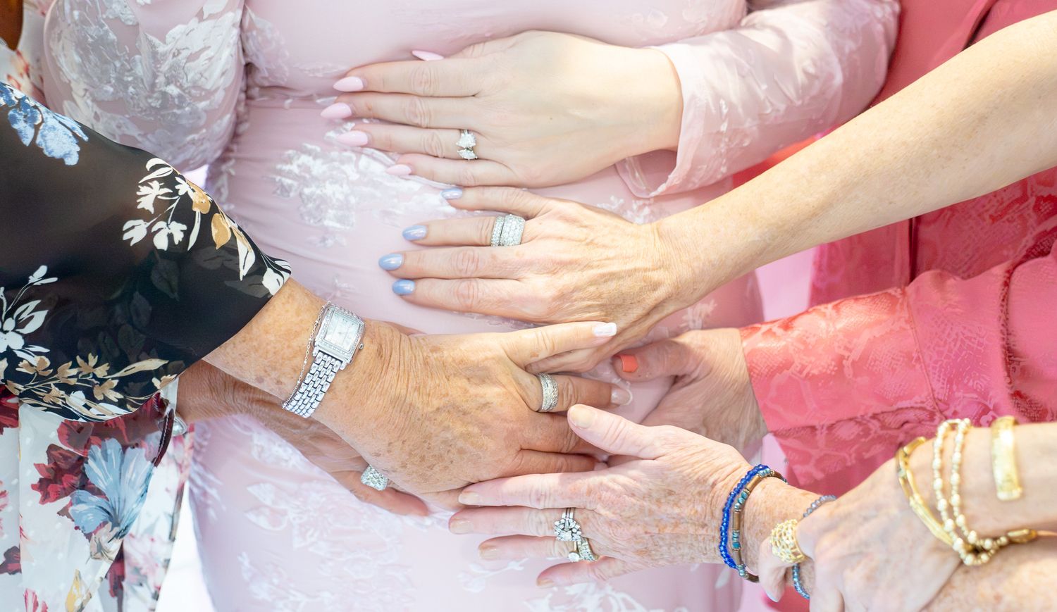women's hands touching pregnant stomach