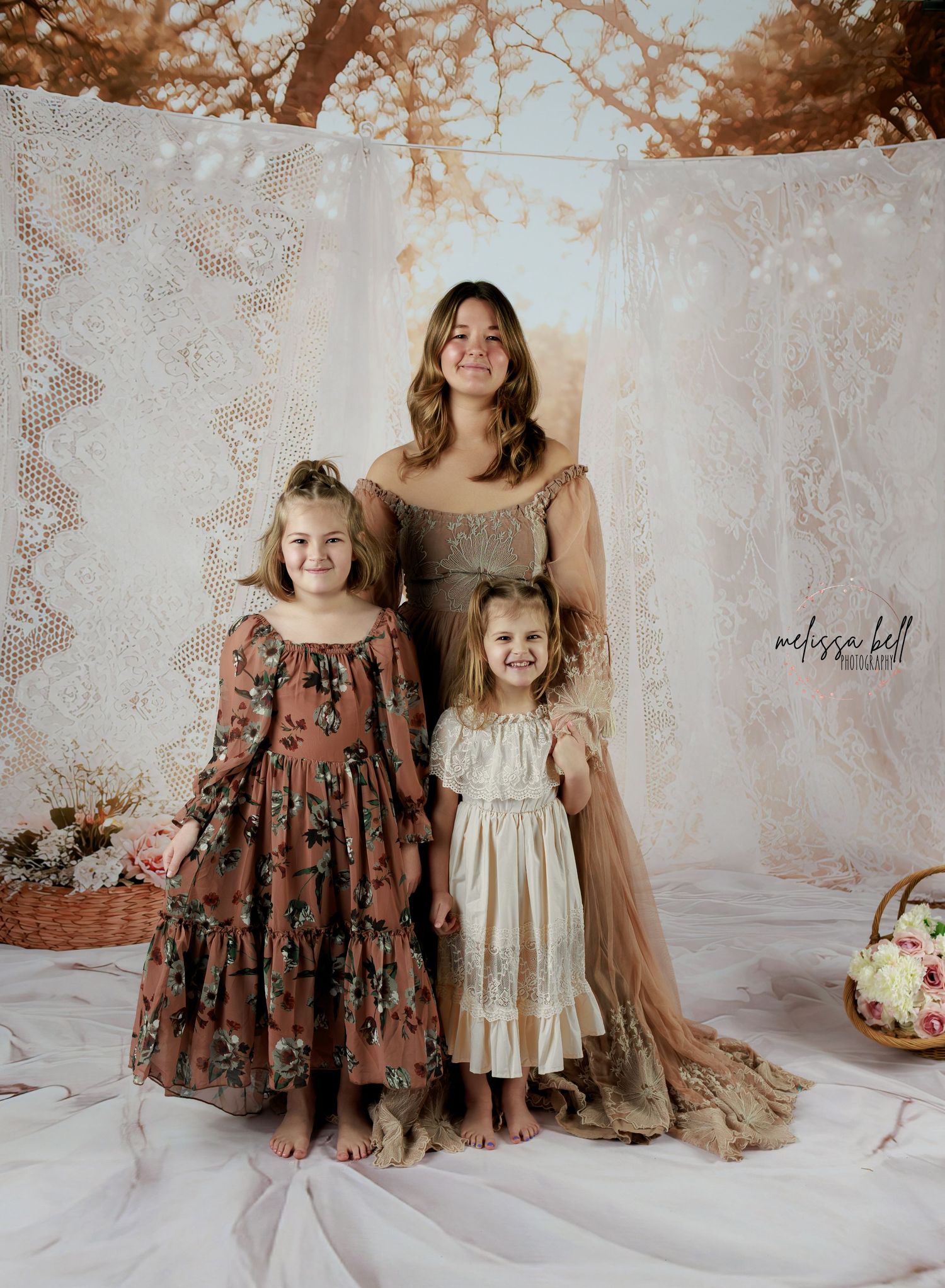 Vintage-style portrait against lace backdrop with soft sepia tones featuring elegant dresses and ethereal styling.