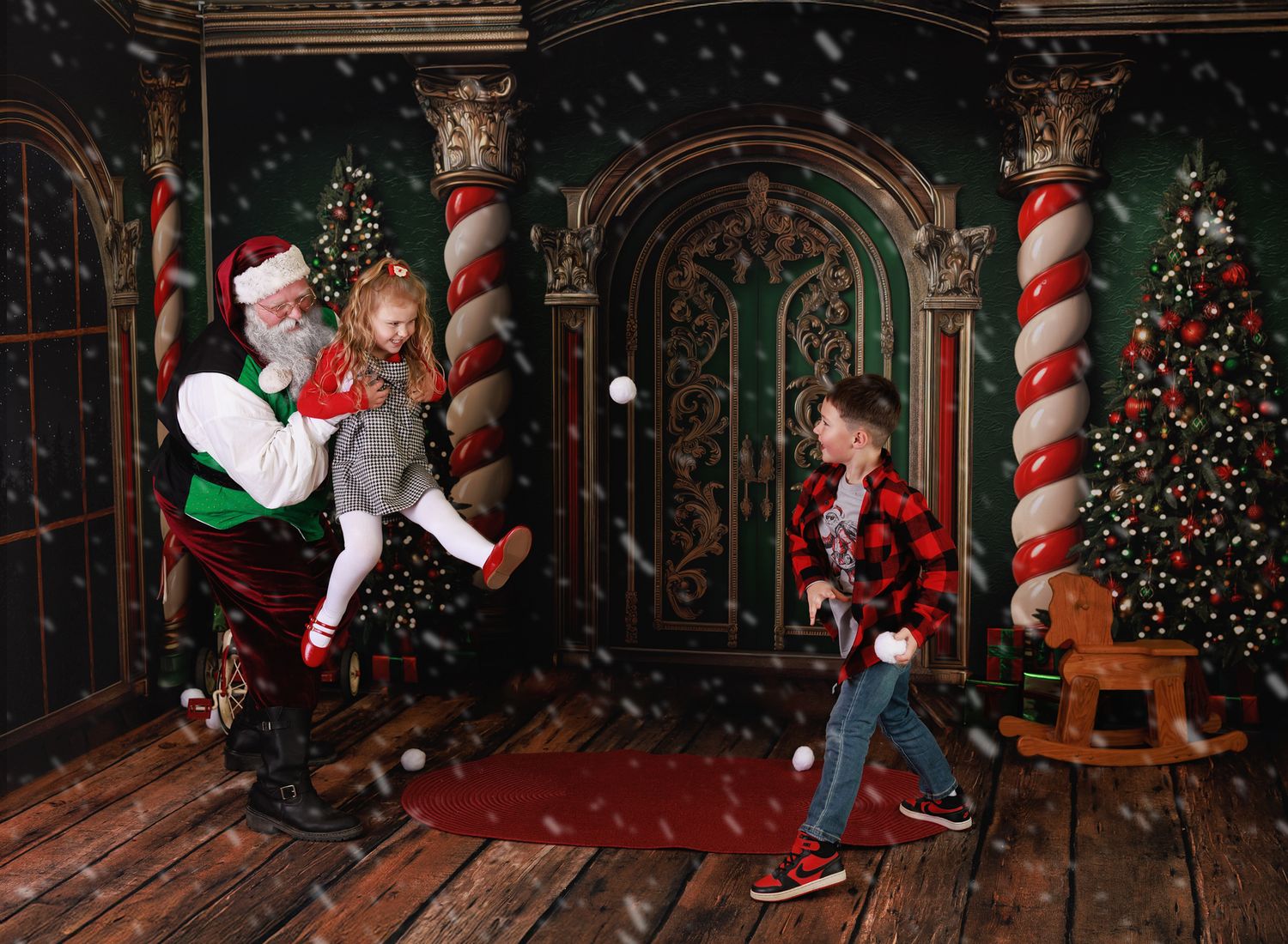 Santa Claus plays with two children in a festive Christmas room with decorated trees and candy cane pillars.