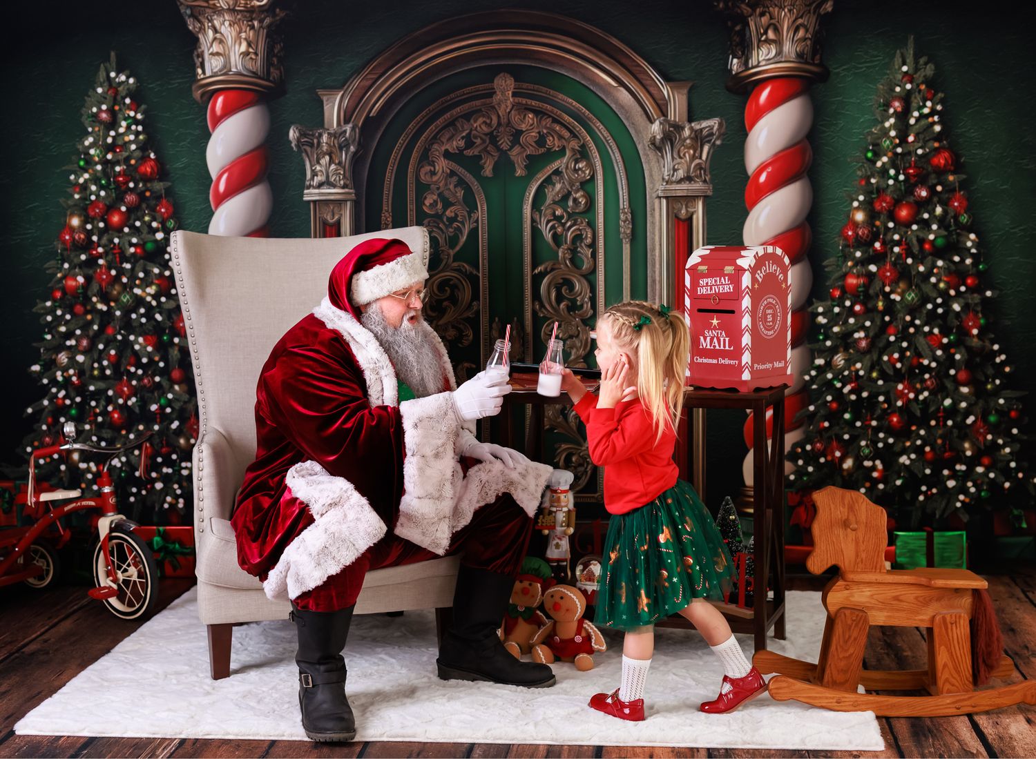 A young girl in red and green meets Santa Claus beside decorated Christmas trees in a festive holiday portrait.