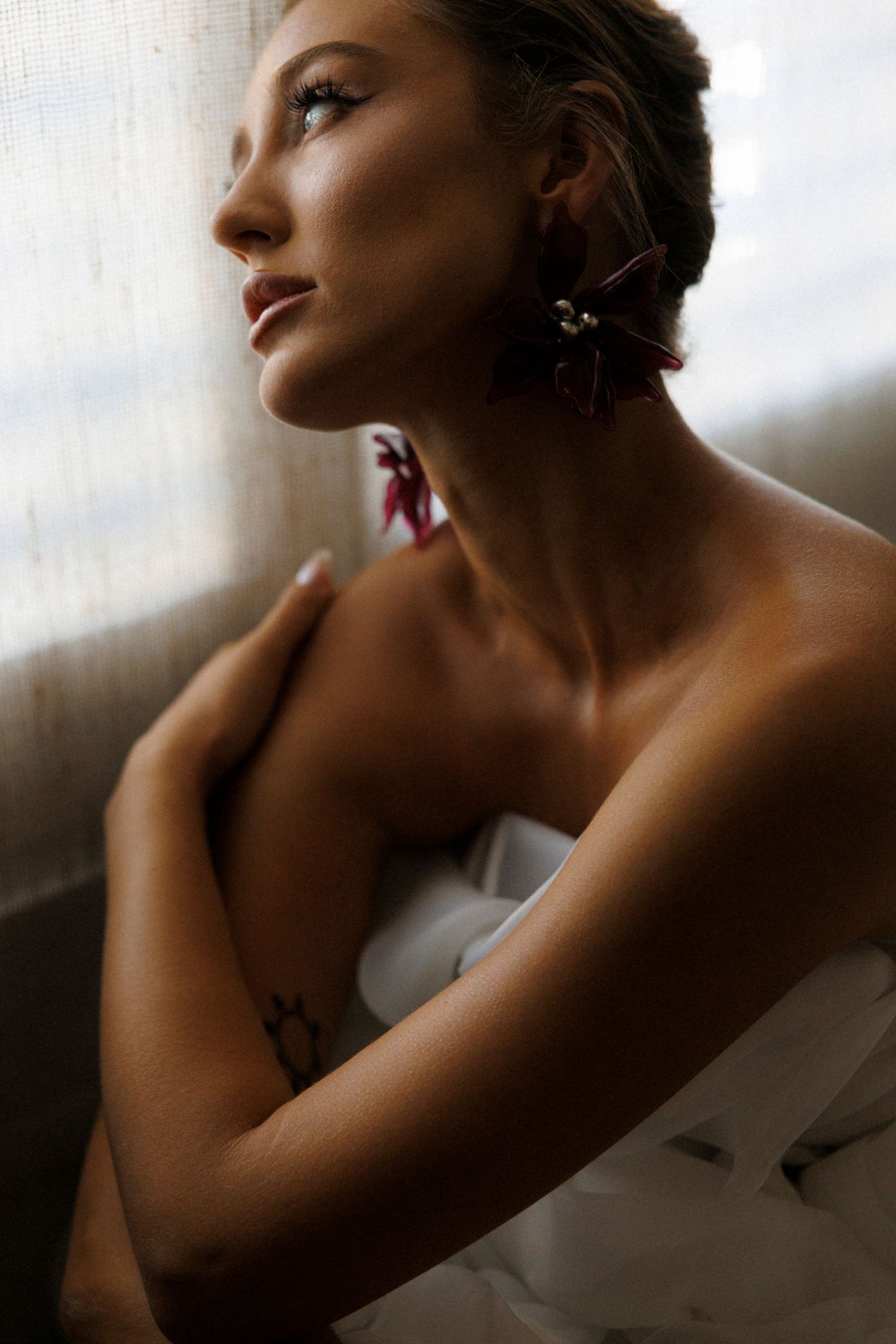 Artistic portrait series showing a person in dramatic side lighting against a window creating a moody silhouette effect.
