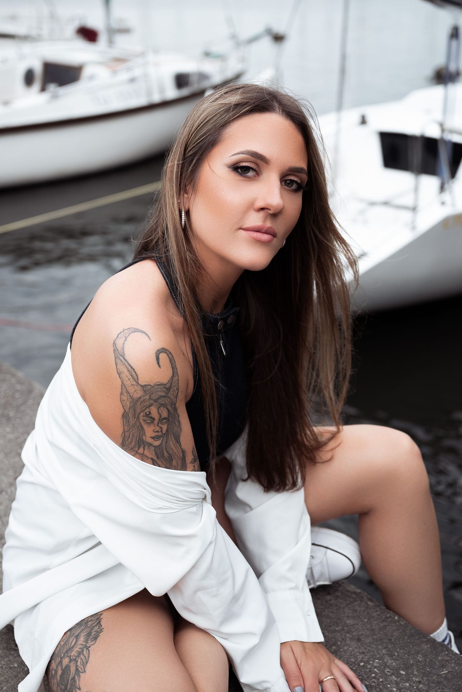 Waterfront photo series with white shirt and visible tattoos near boats.