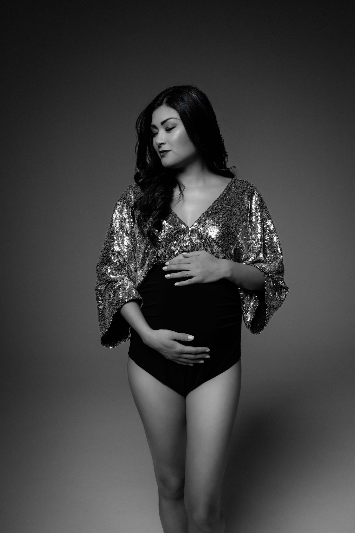 Black and white artistic portrait series showing a figure in a sequined top posing against a dark background.