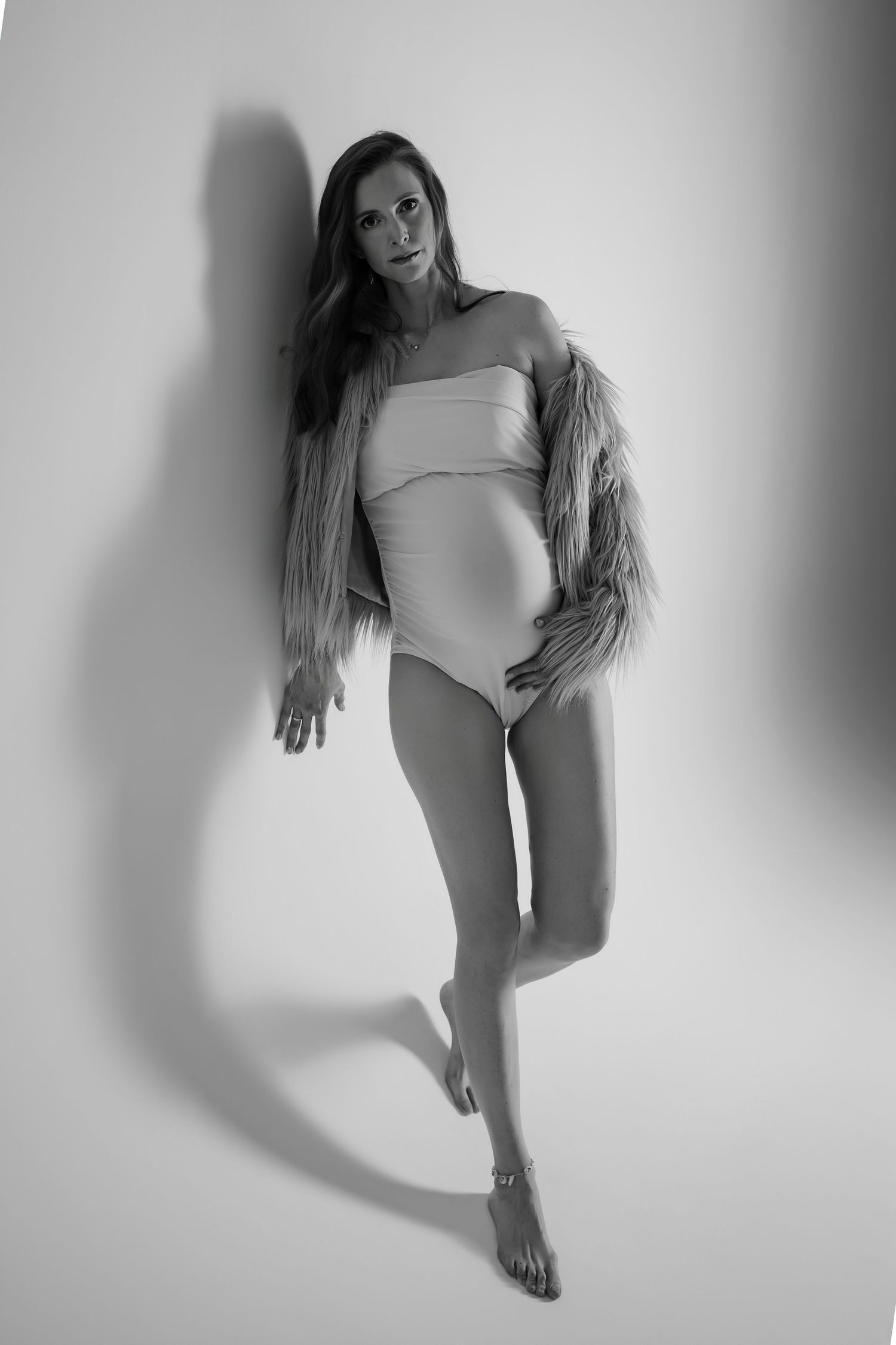 Black and white artistic photo series showing a dancer in a leotard performing expressive movements against a white backdrop.