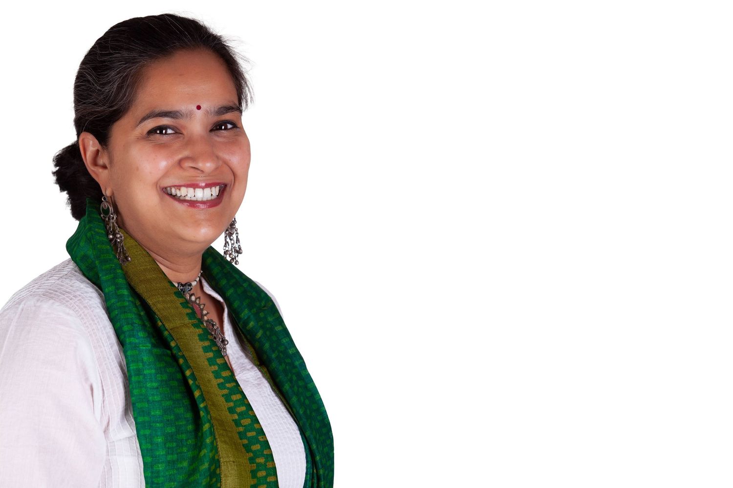 A smiling person wearing a white top and green scarf poses in a series of headshots against a light background.