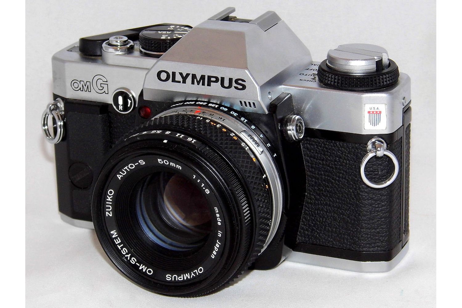 A collection of vintage Olympus film cameras and lenses arranged in a row showing different angles and models.