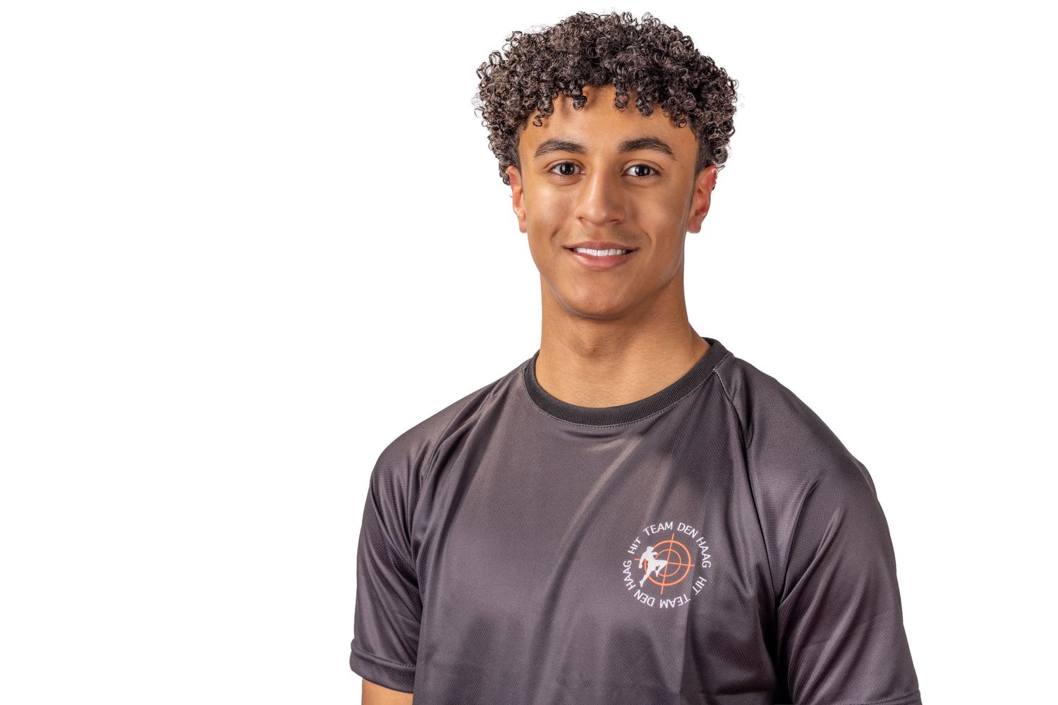 Young athlete in gray athletic wear poses for a sports photo against white background.