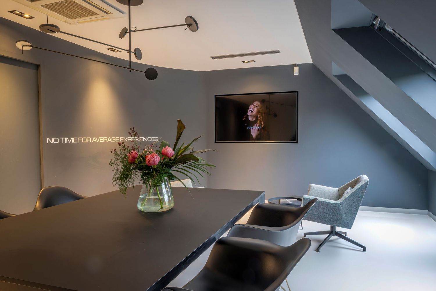 Modern office workspace with sleek desk, ergonomic chair, and natural lighting through large windows.