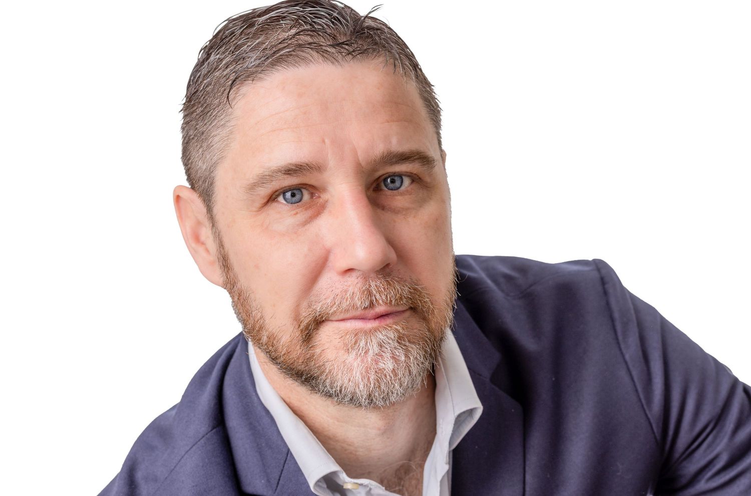 Professional headshot of someone wearing a navy blue blazer and white shirt against a white background.