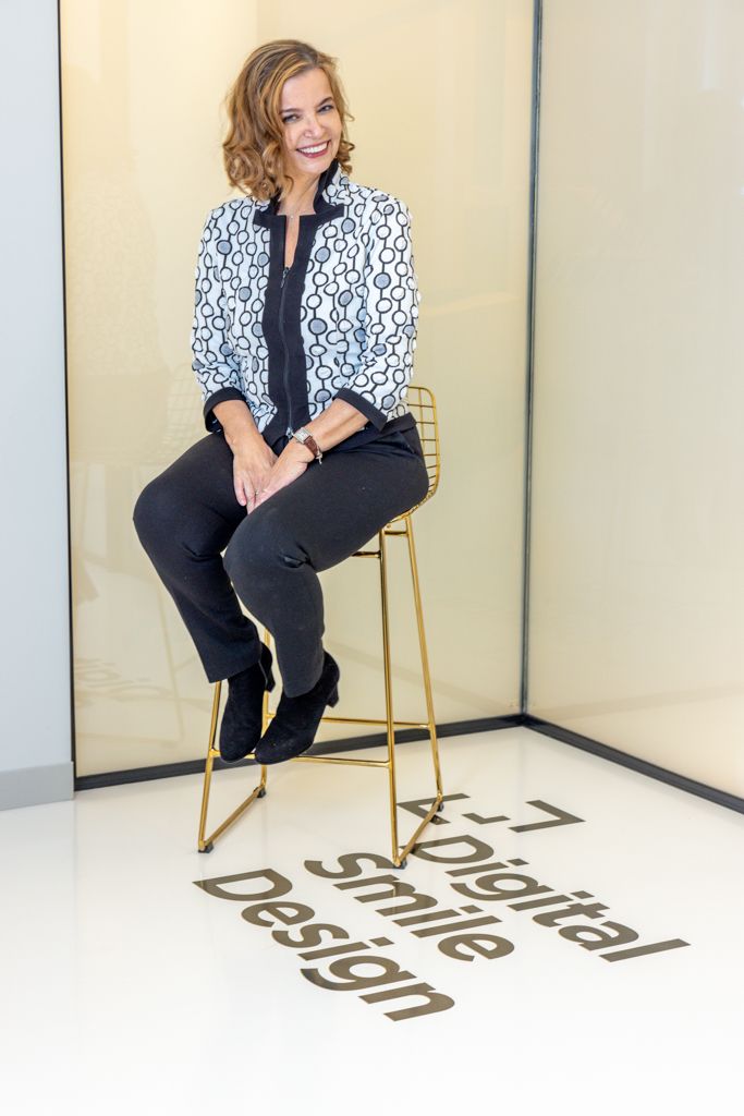 Professional studio photos show a model in a black and white patterned blazer and black pants posing on a gold chair.