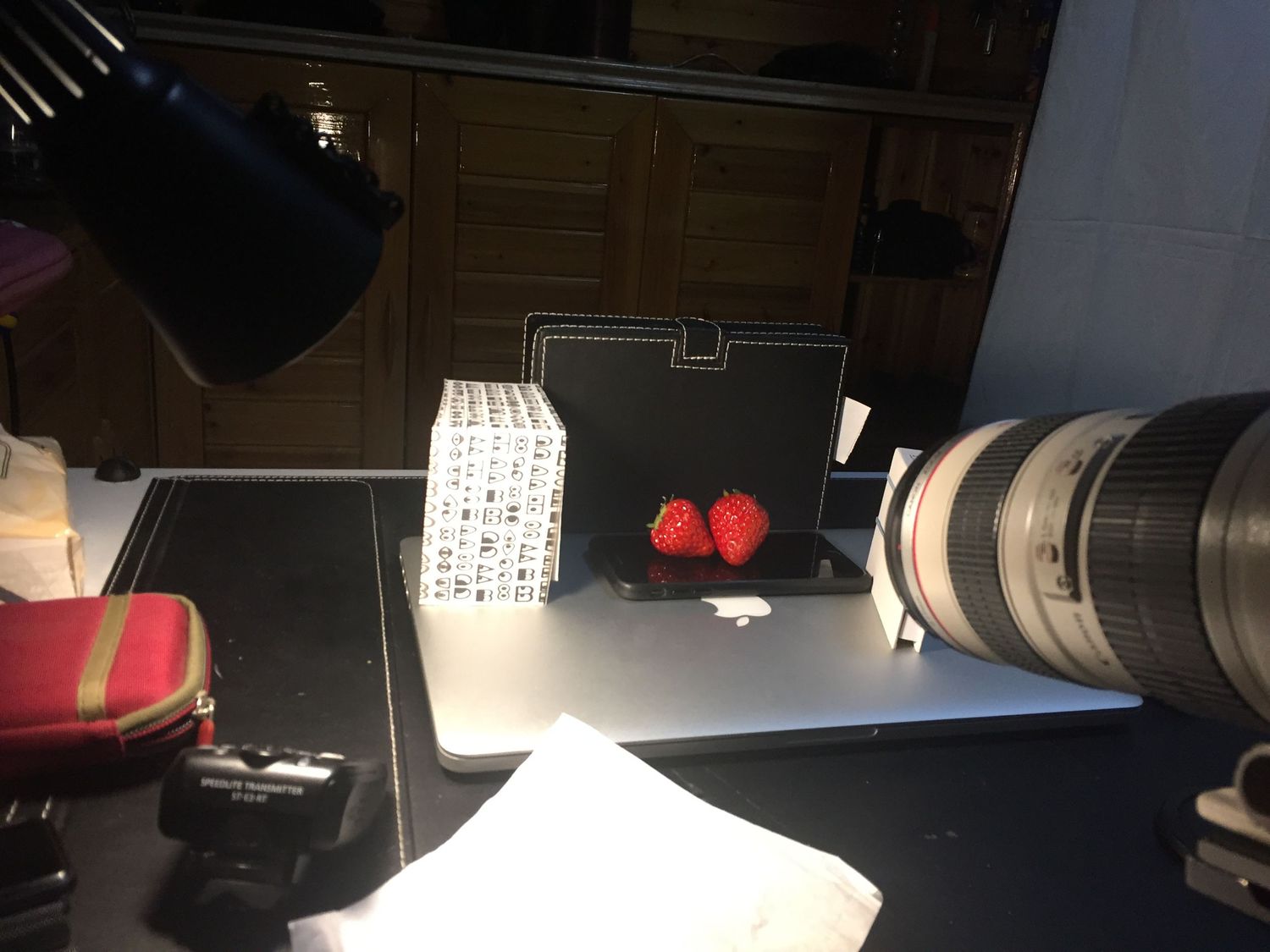 Behind the scenes photo setup for strawberry product photography with lighting equipment.