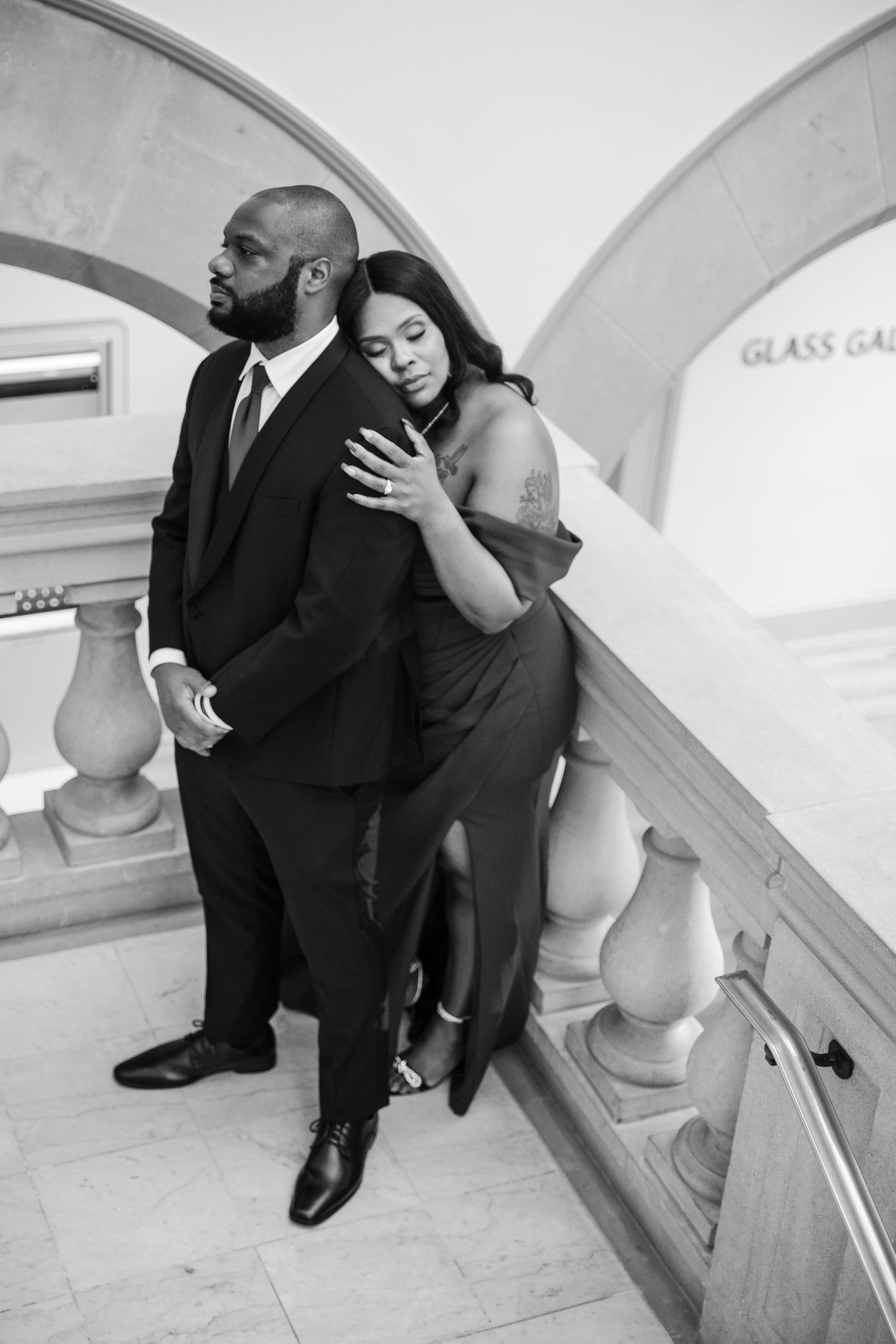 Black and white photos of couple on architectural staircase during photoshoot.