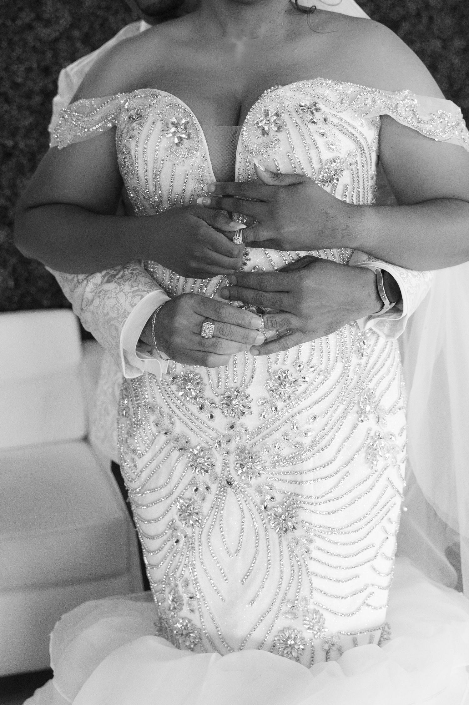Close-up details of an ornate white wedding dress with beaded embellishments and sequin patterns.