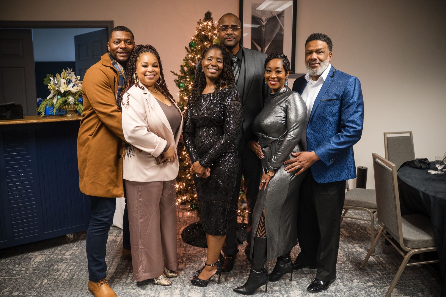 People gather for a group photo at an indoor event with warm lighting and professional setting.