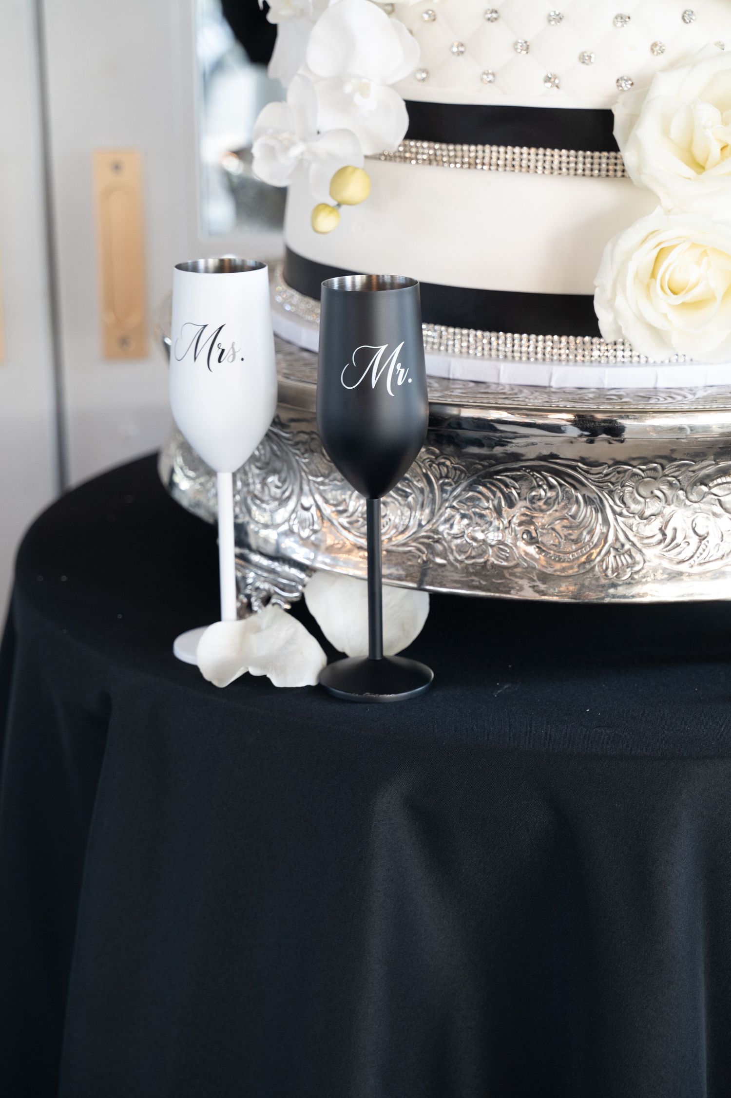 Elegant black and white wedding decor with wine glasses labeled Mr. and Mrs. on a silver tray.