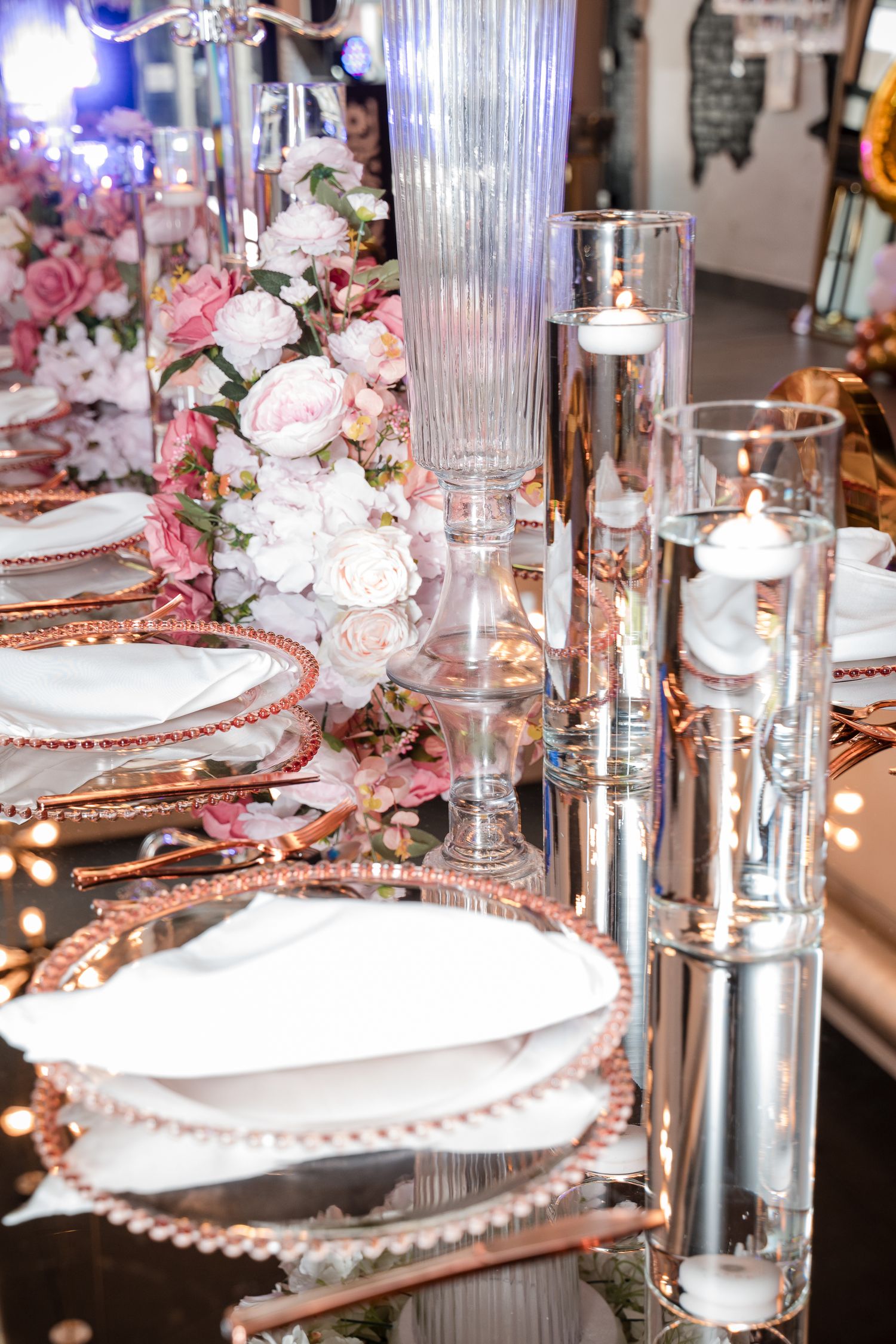 Close-up of elegant place settings with crystal glassware and rose gold details.