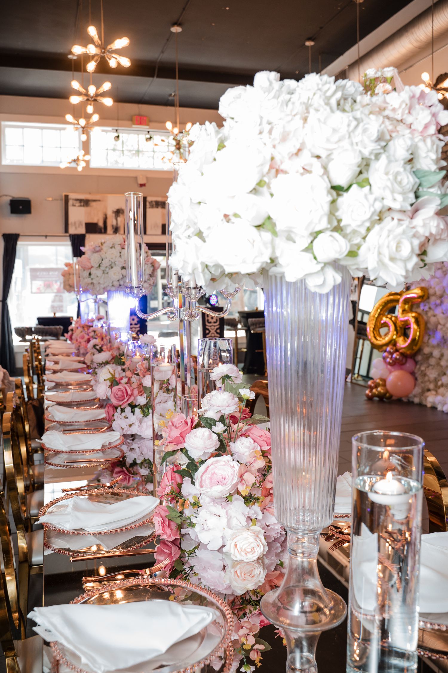 Luxurious table settings with crystal vases, white flowers and rose gold accents.