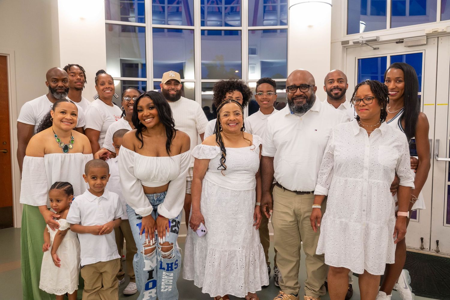 Group photos of guests in white and light-colored formal attire at an indoor celebration.