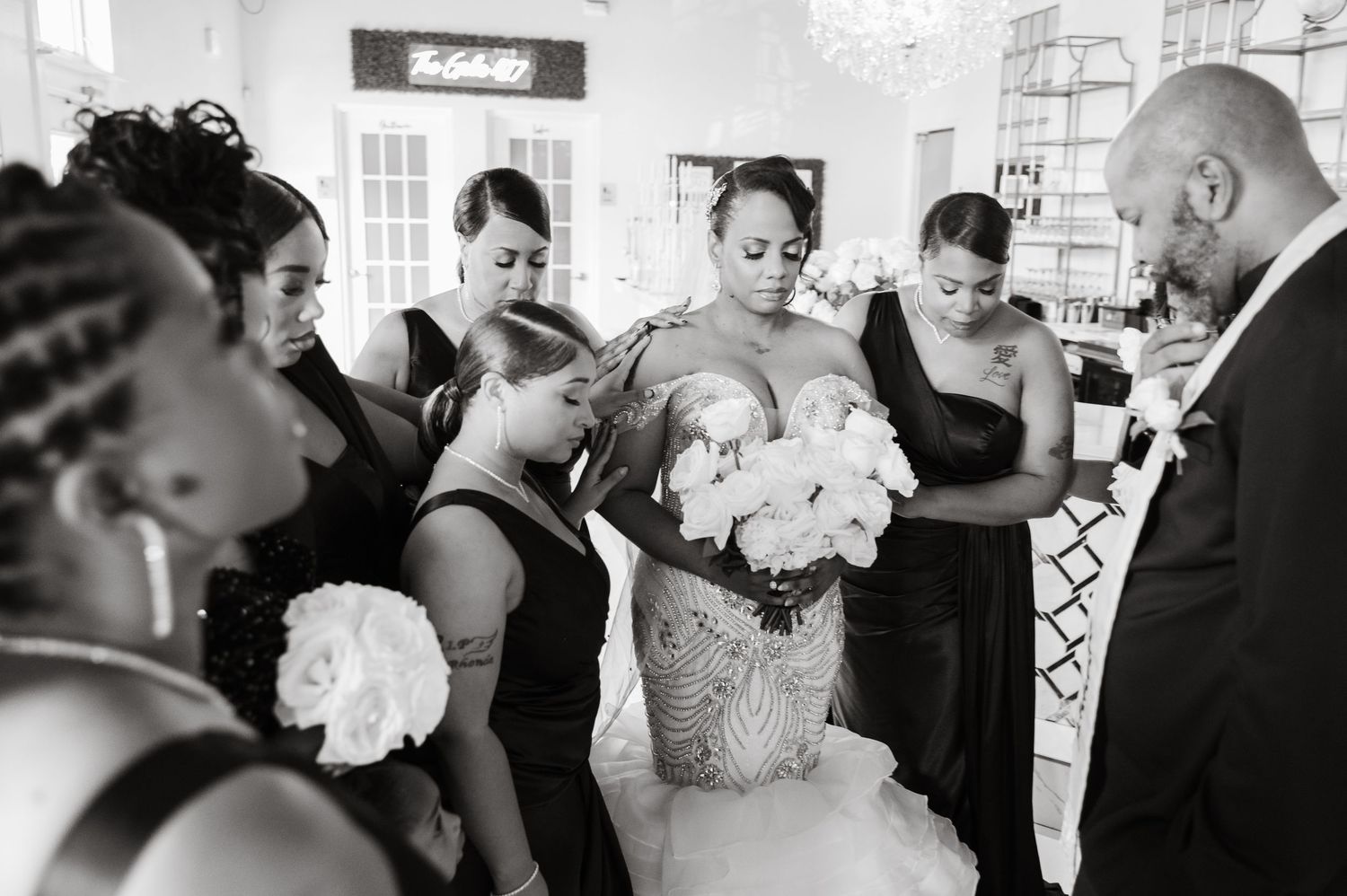 Black and white photo of wedding ceremony guests mingling in elegant venue.