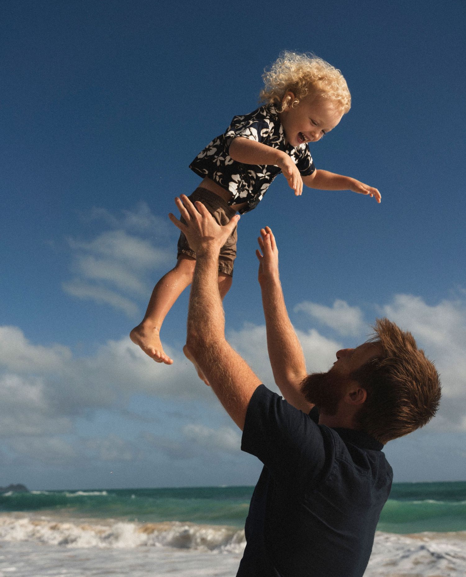 Parents and children playing on the beach, candid family photography