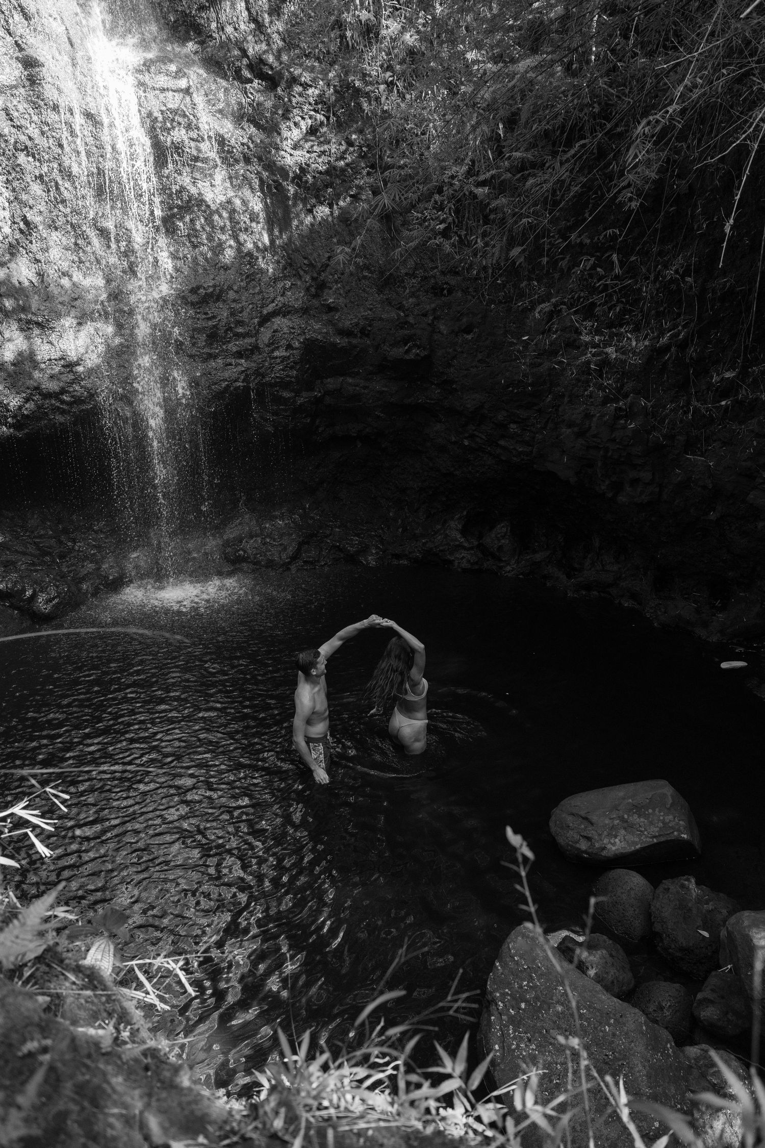 Black and white photos show a dark cave interior with a waterfall and pool surrounded by rocky formations.