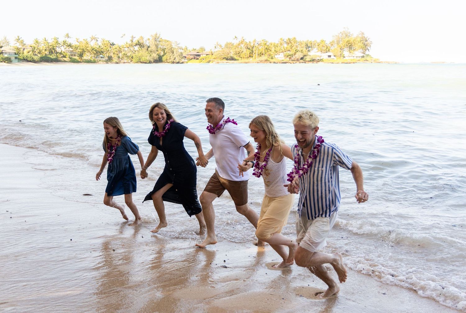 Parents and children playing on the beach, candid family photography