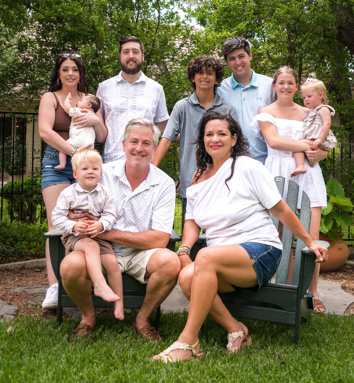 Family members relaxing on outdoor garden furniture surrounded by lush greenery.
