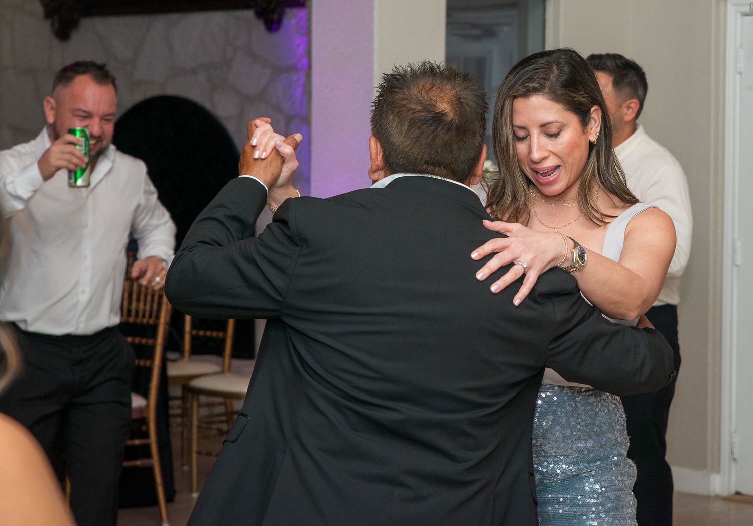 People dancing and celebrating at an indoor party venue.
