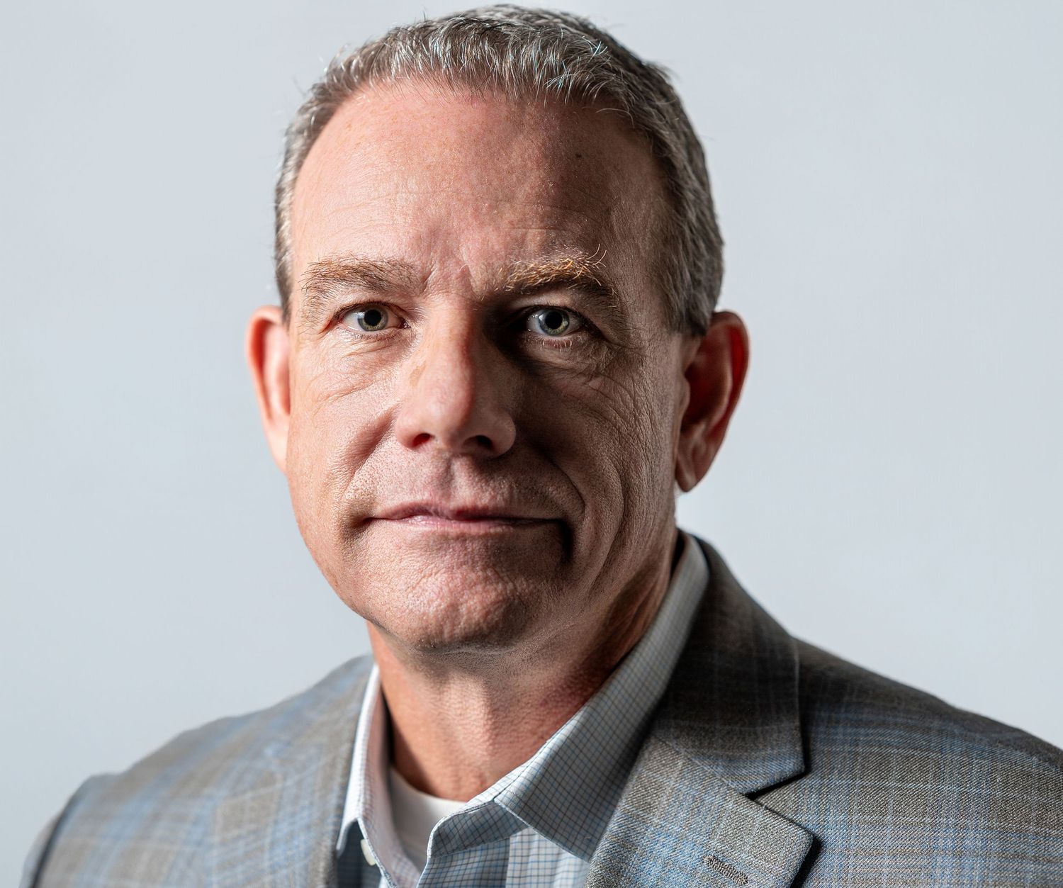 A series of professional headshots showing the same person in business attire with varying expressions.